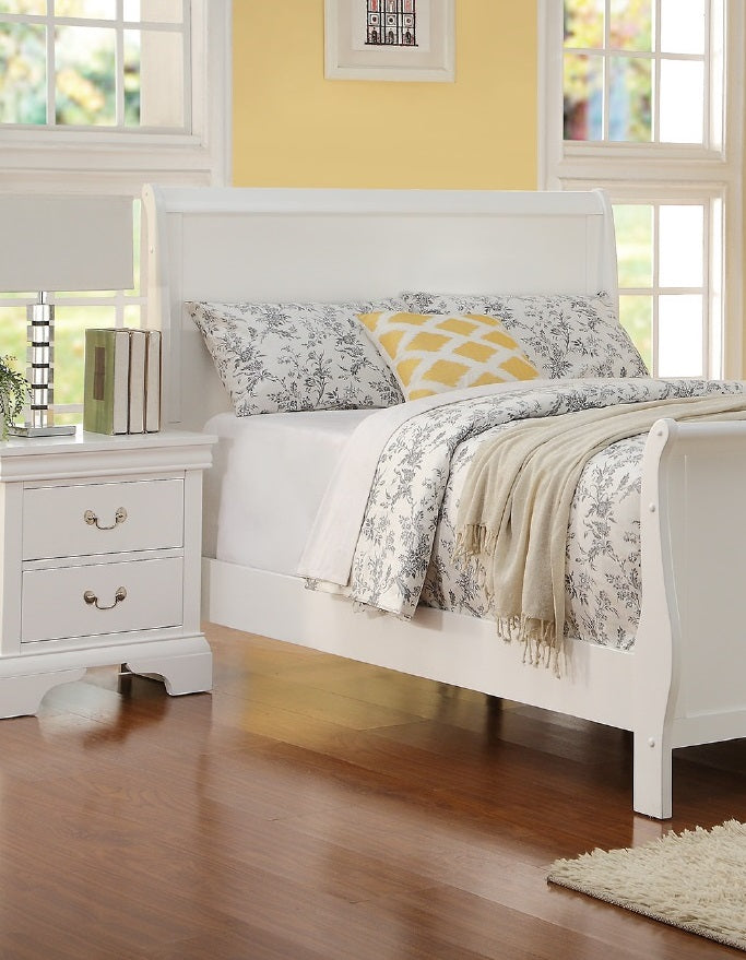 White sleigh bed frame with floral bedding and a yellow accent pillow