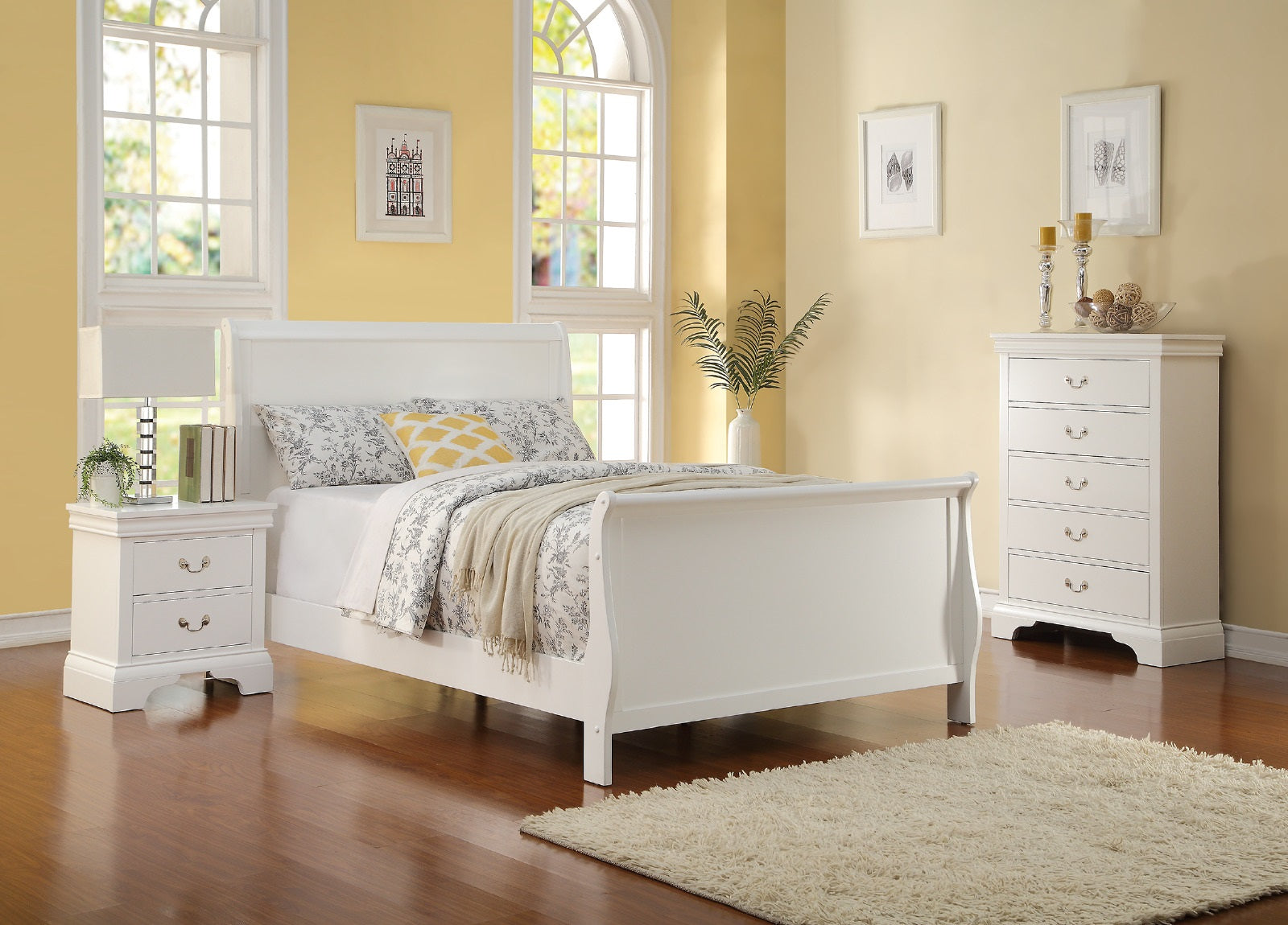 White sleigh bed with floral bedding and yellow accent pillow