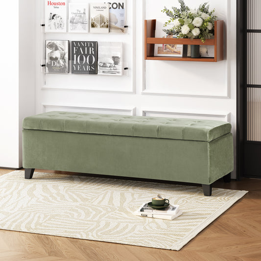 Sage green velvet storage bench with tufted top and dark wood legs