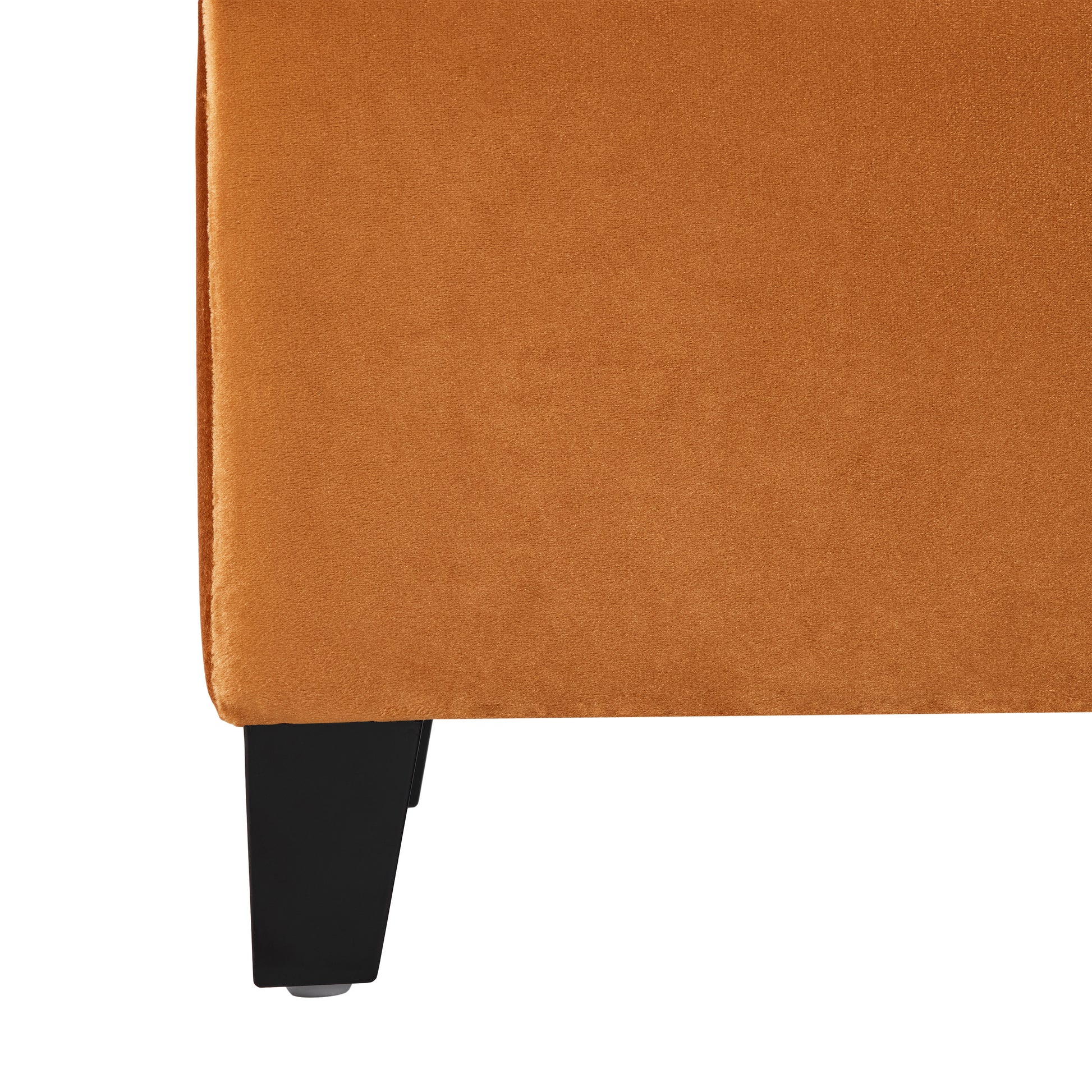 Closeup of burnt orange velvet upholstery on a modern armchair leg