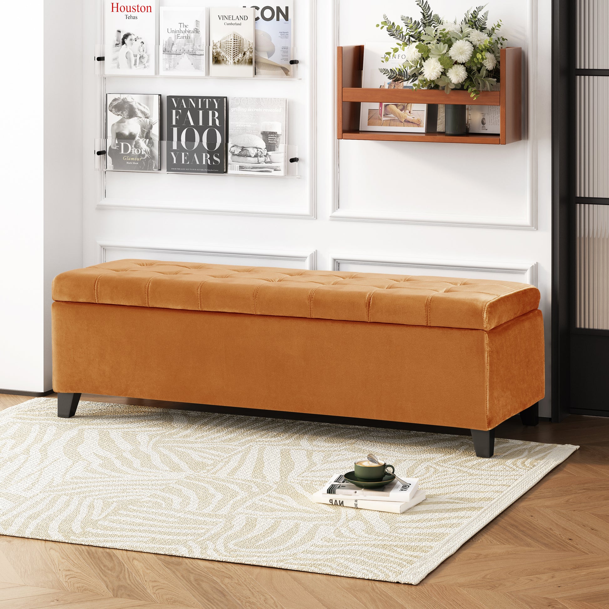 Tufted orange velvet storage ottoman with black legs and a modern design