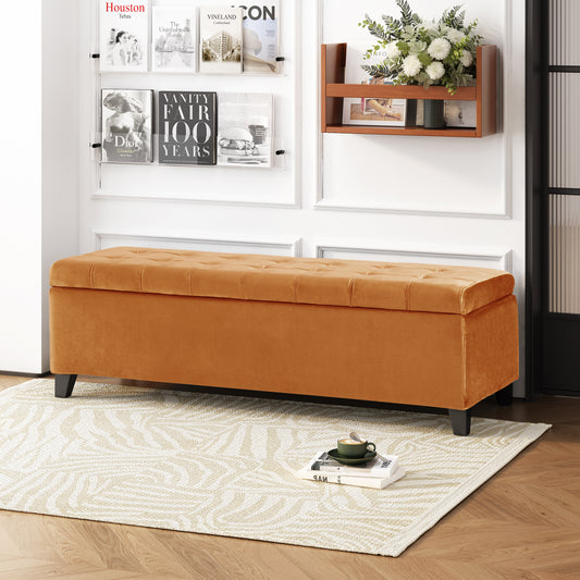 Tufted orange velvet storage ottoman with black legs and a modern design