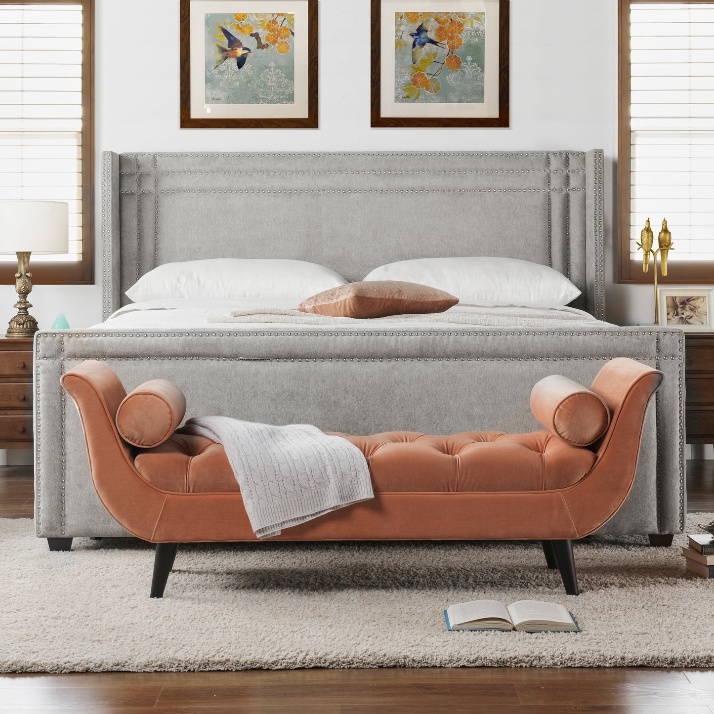 Orange velvet tufted bench with rolled arms and a white throw