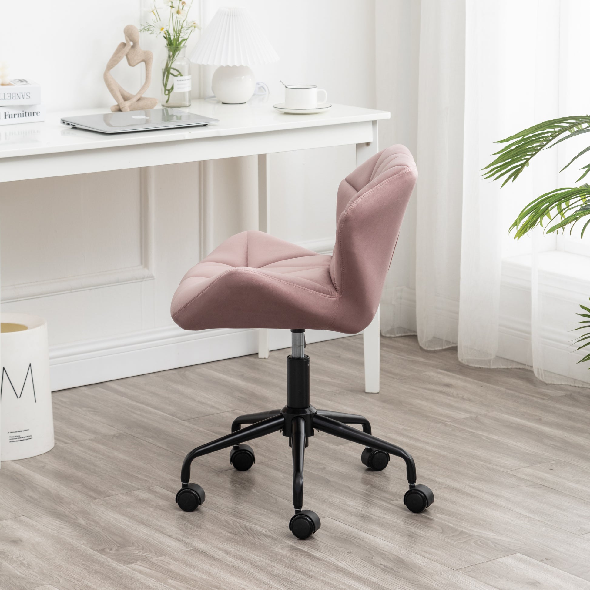 Upholstered pink office chair with tufted diamond pattern and black swivel base