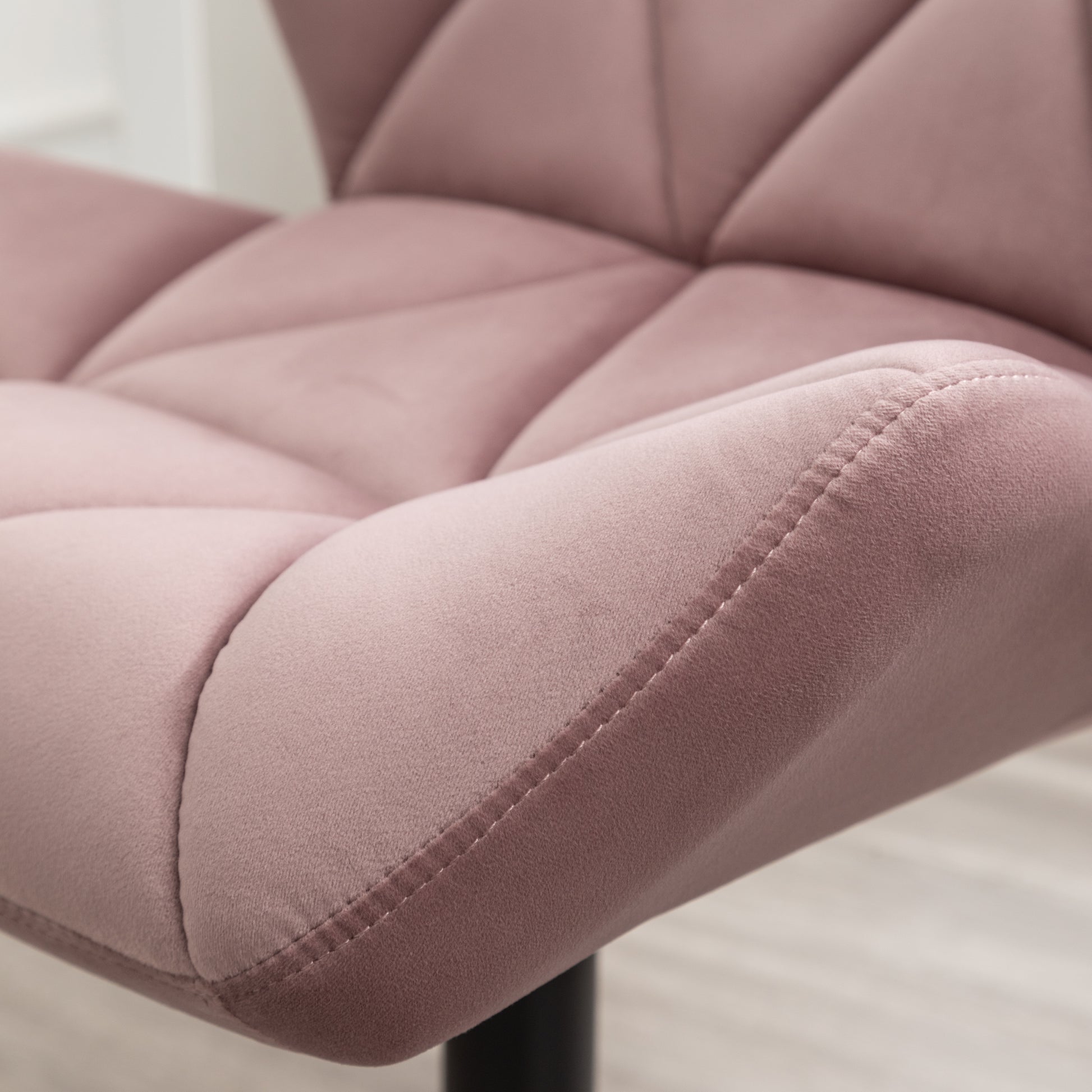 Close up of a plush rose velvet armchair with diamond tufting