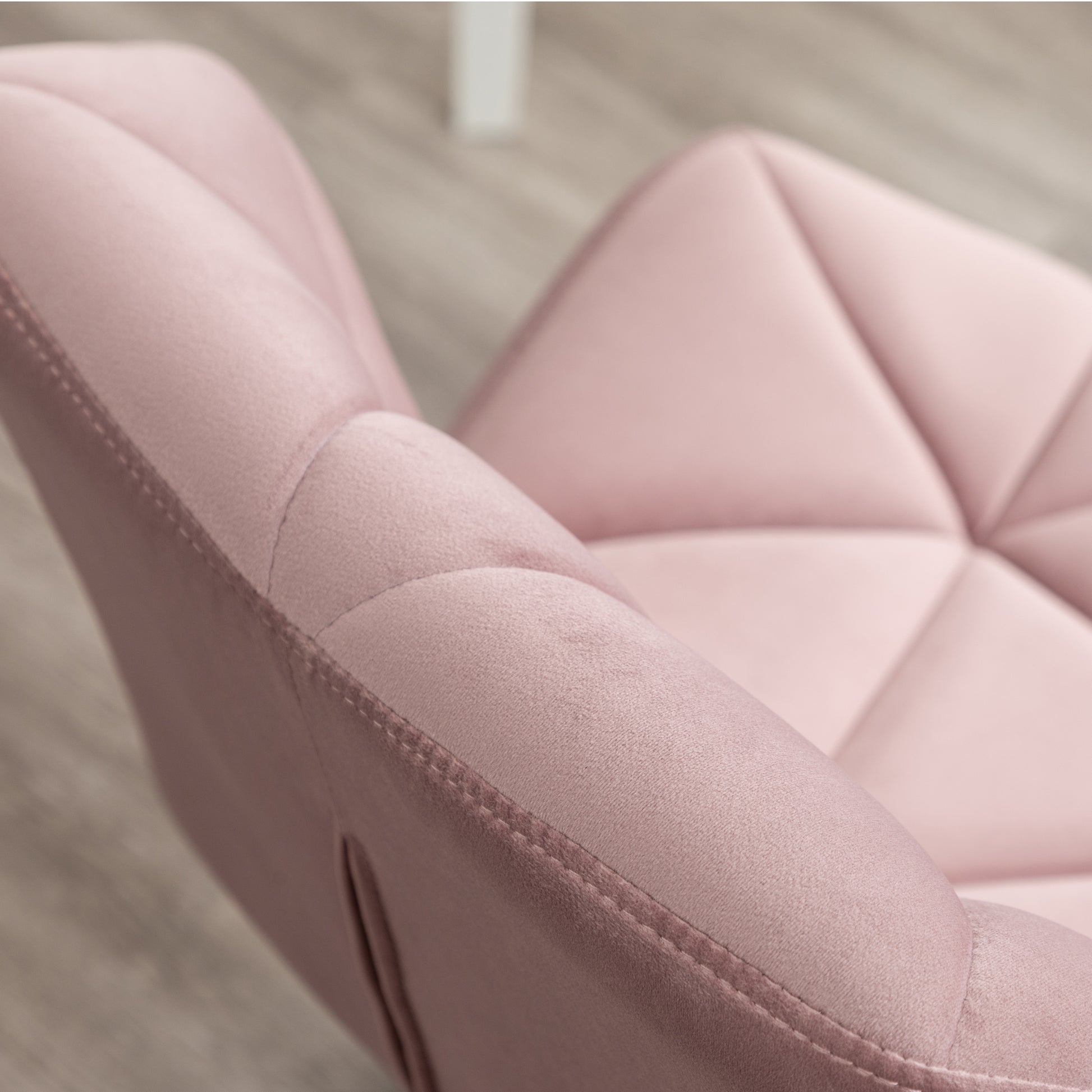 Closeup of a plush pink velvet chair with diamond tufting