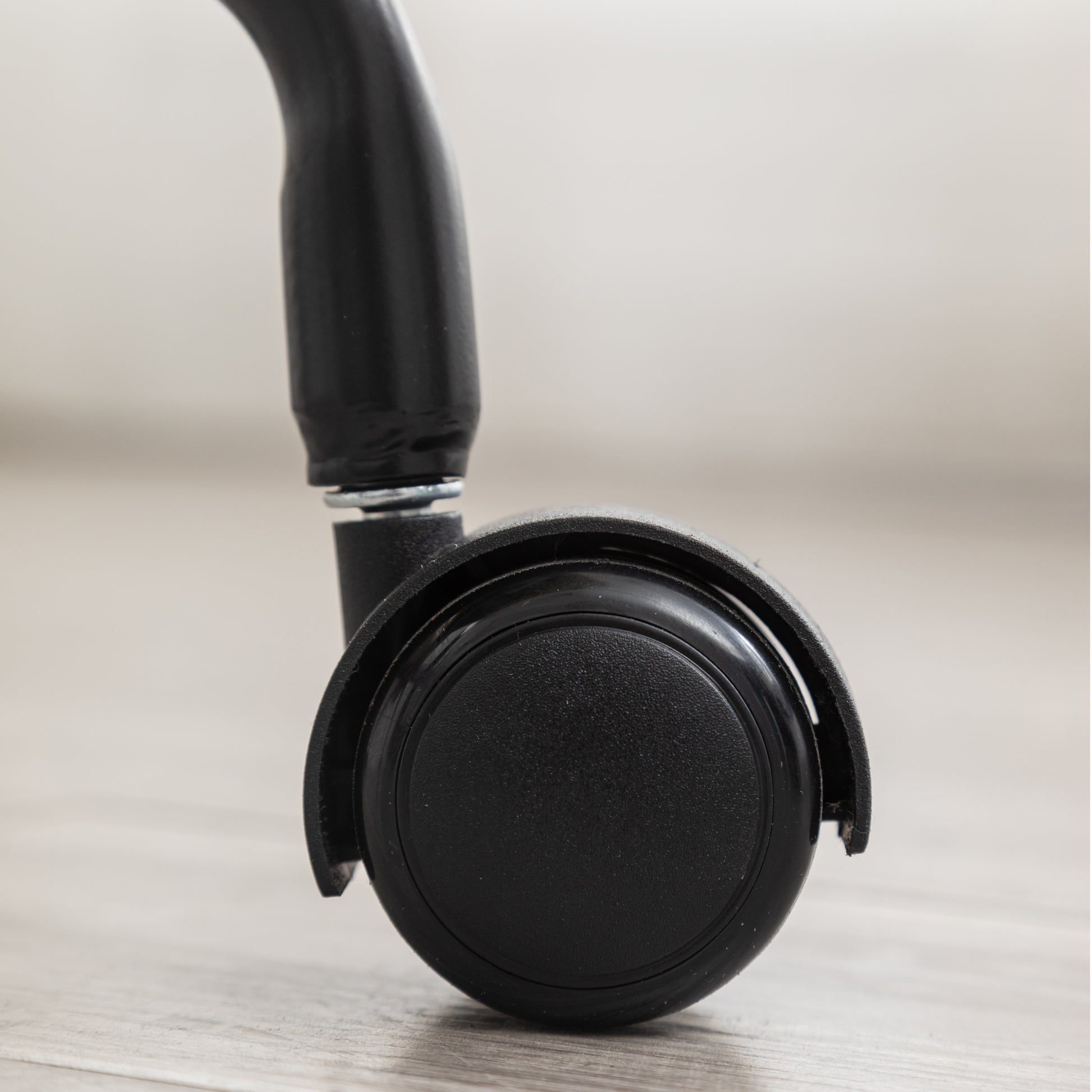 Black office chair caster wheel with textured surface for smooth movement on floors