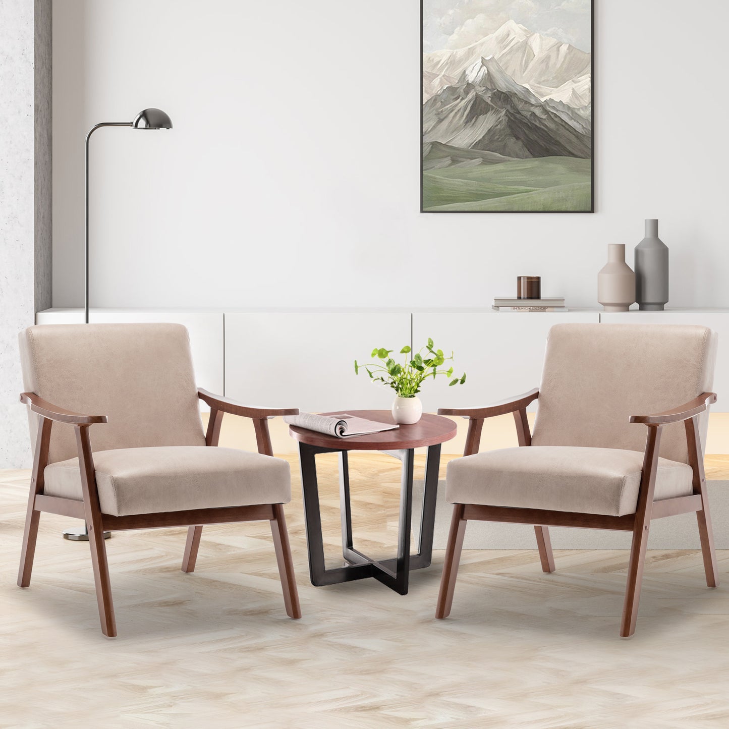 Two beige accent chairs with wooden frames flanking a round wood coffee table with a plant