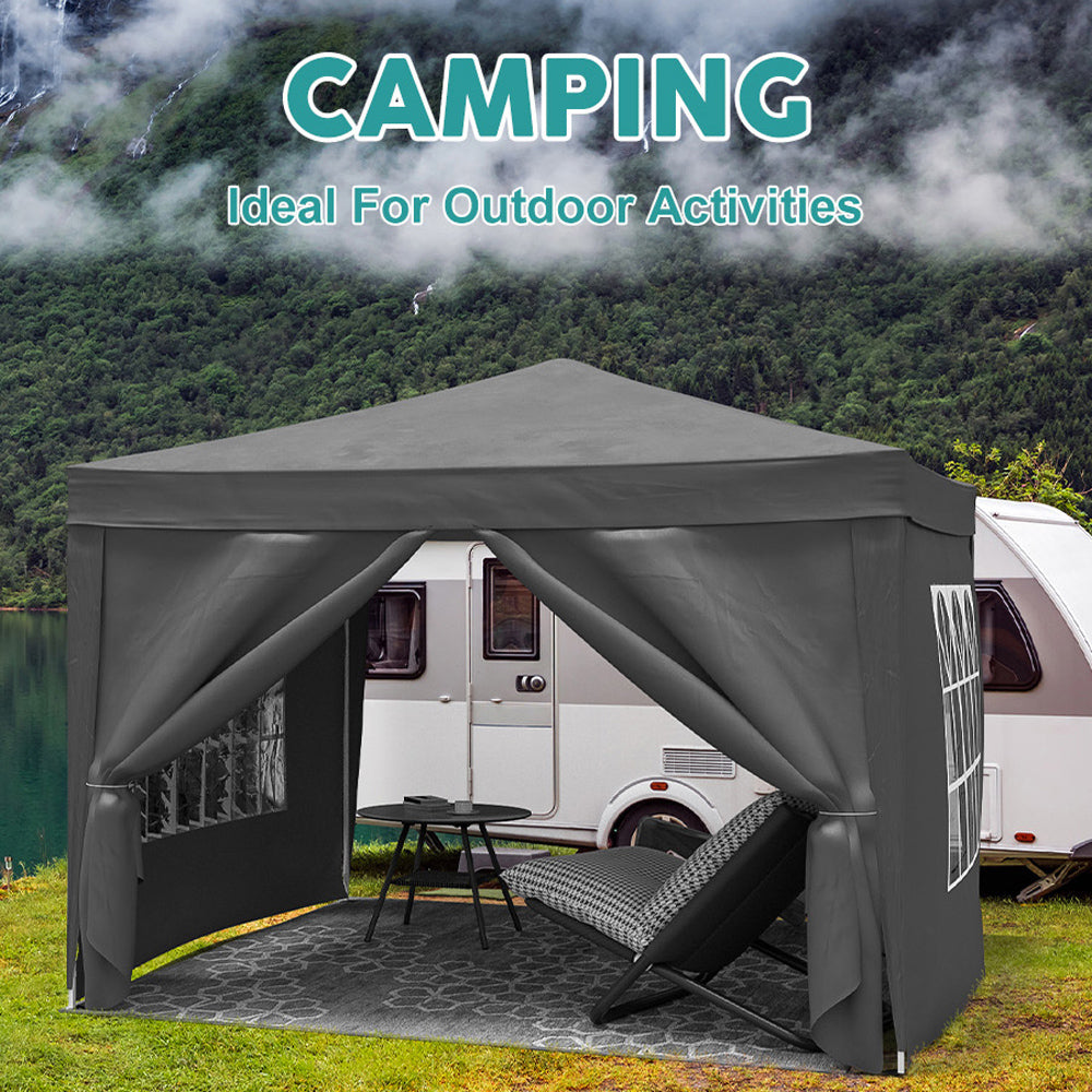 Dark gray popup canopy tent with RV and lake in background