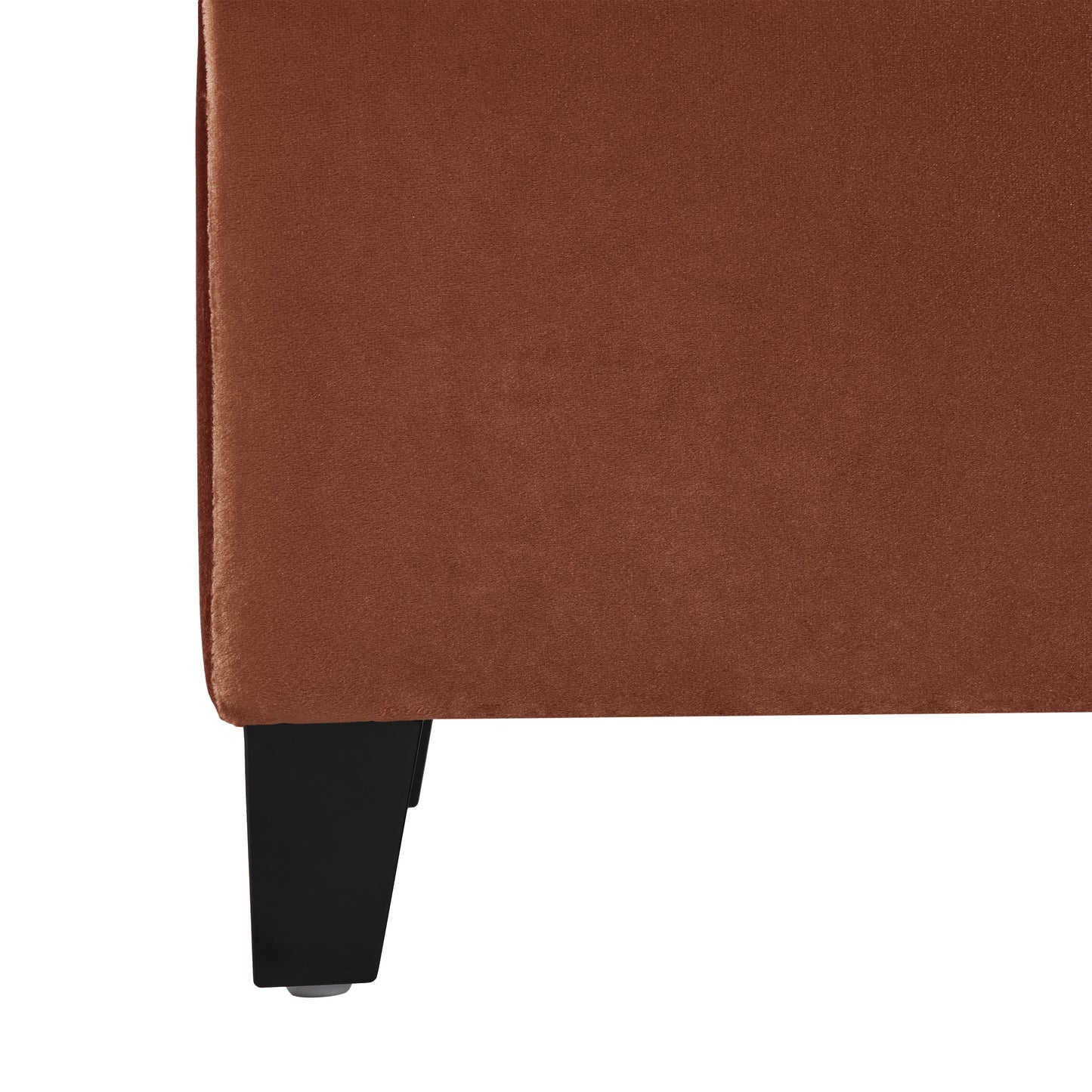 Closeup of a rich copper velvet sofa corner with black legs soft texture