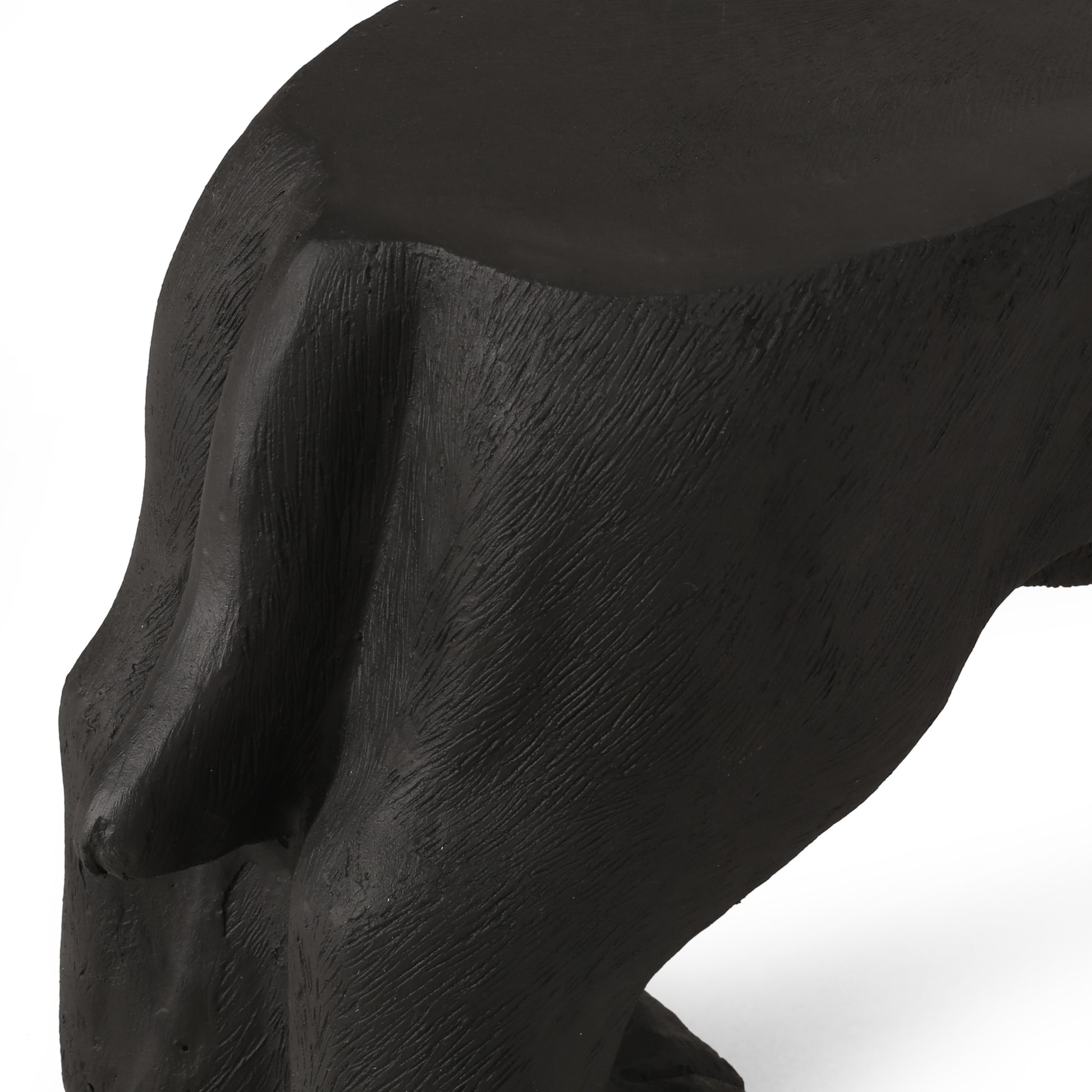 Closeup of a black textured bear sculptures back and hind leg