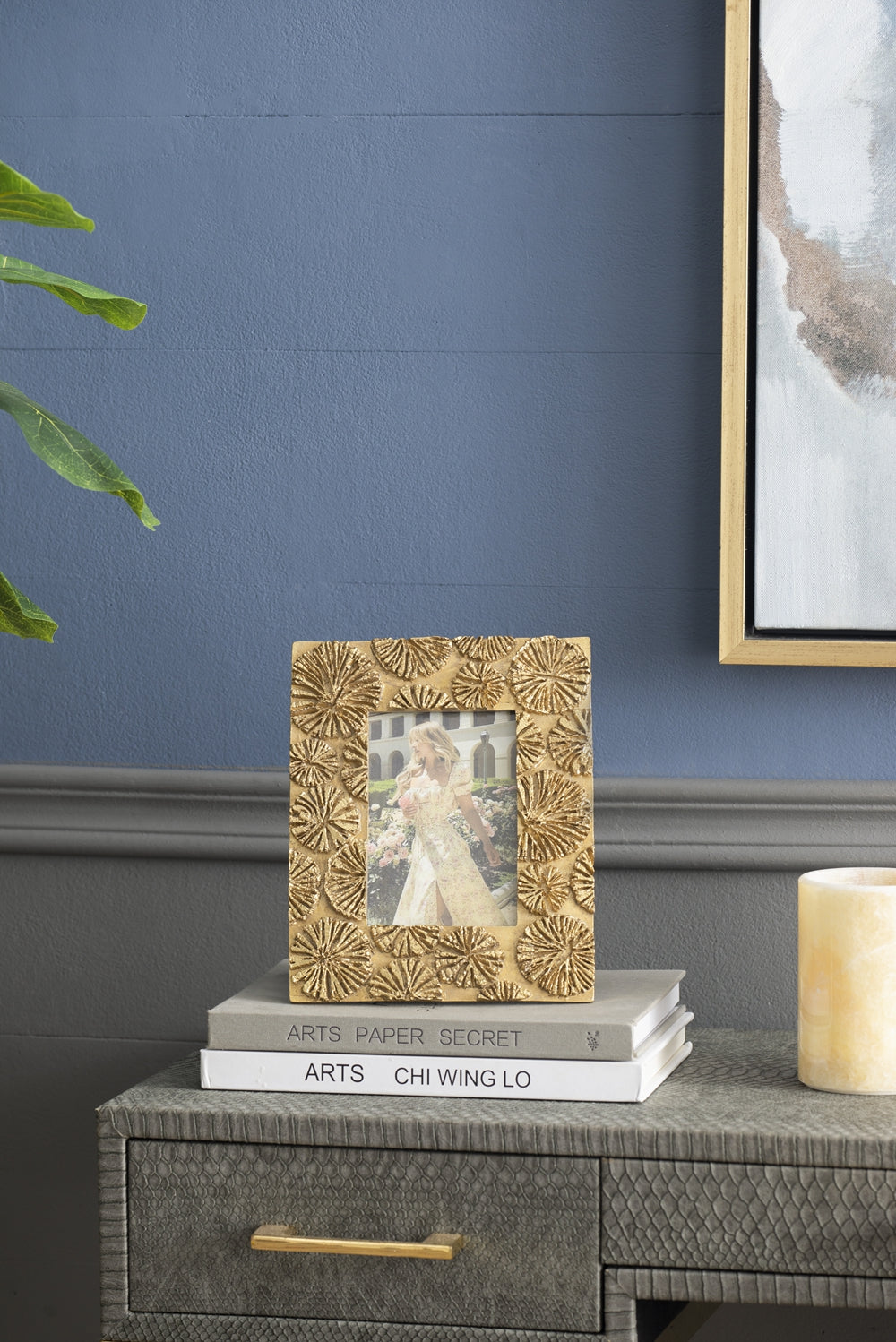 Ornate gold photo frame with a textured floral design holding an image of a woman in a vintage dress