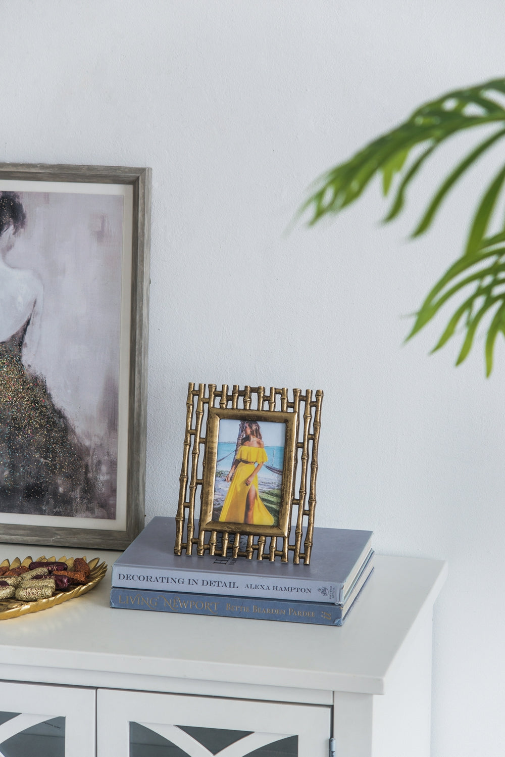 Decorative gold bamboo picture frame with woman in yellow dress on beach