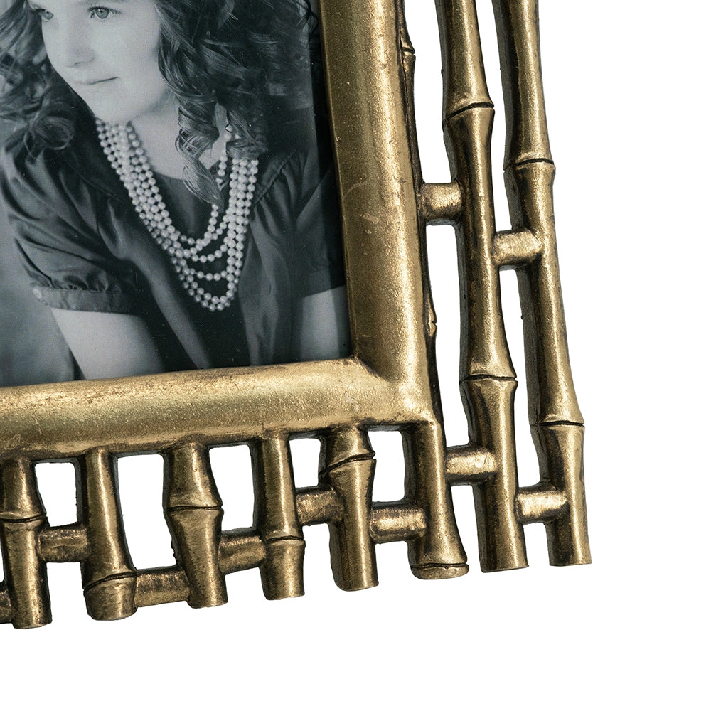 Antique gold bamboostyle picture frame holding a black and white photo of a girl
