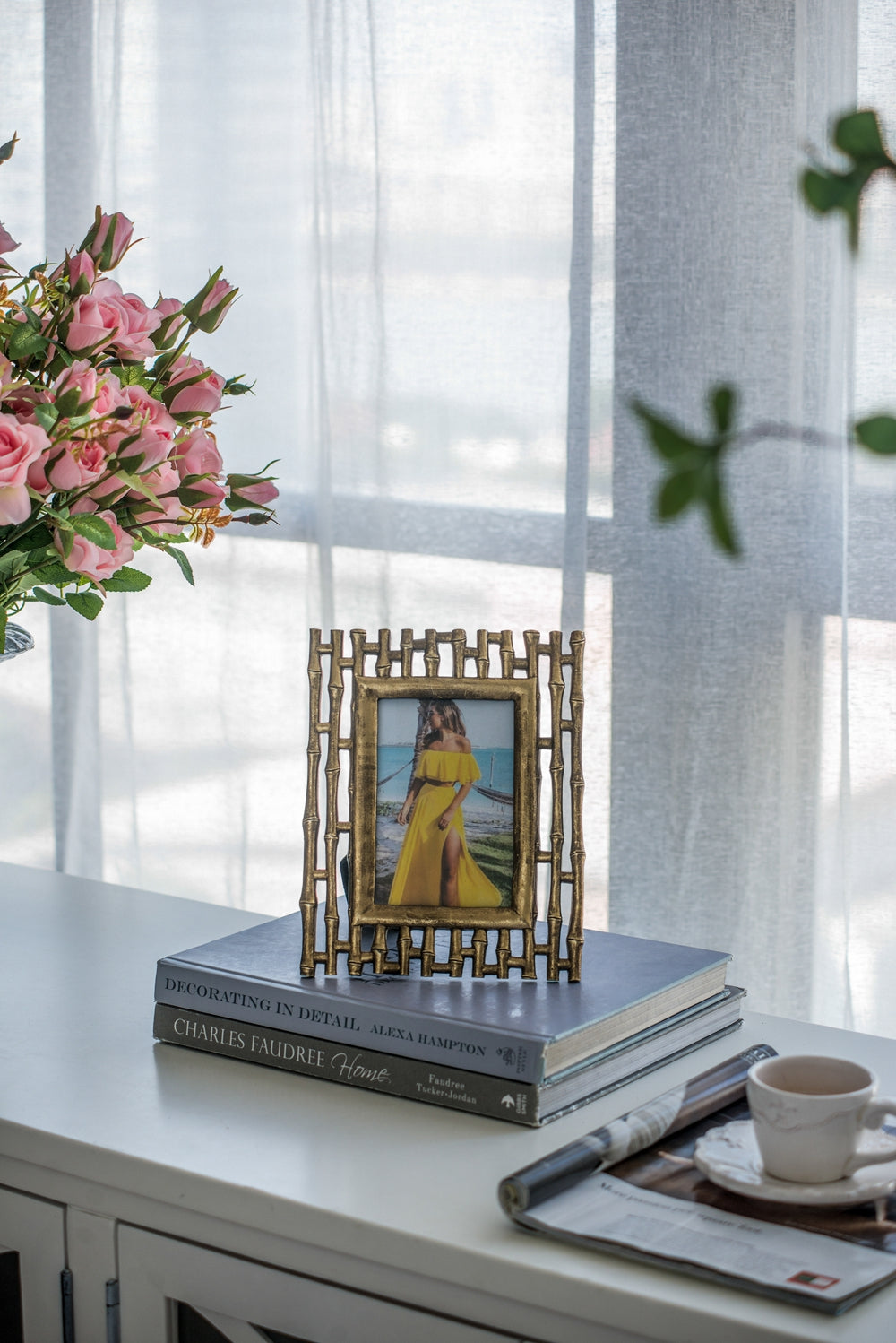Ornate antique brass picture frame with bamboo design holding a photo of a woman in a yellow dress