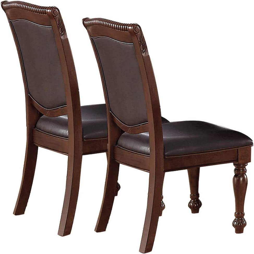 Two dark brown leather dining chairs with ornate wood detailing and carved legs