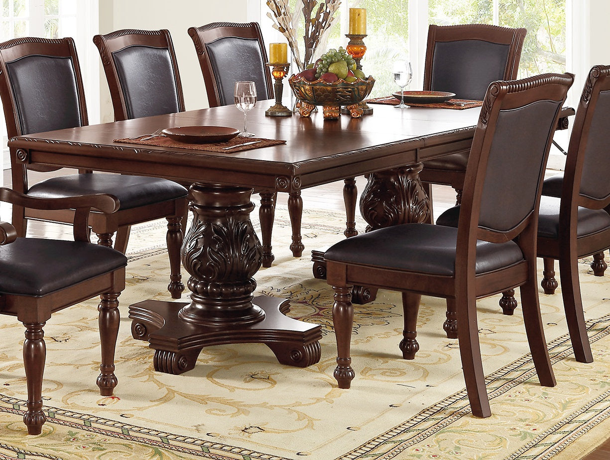 Dark wood dining table set with ornate carved pedestal base and brown leather chairs