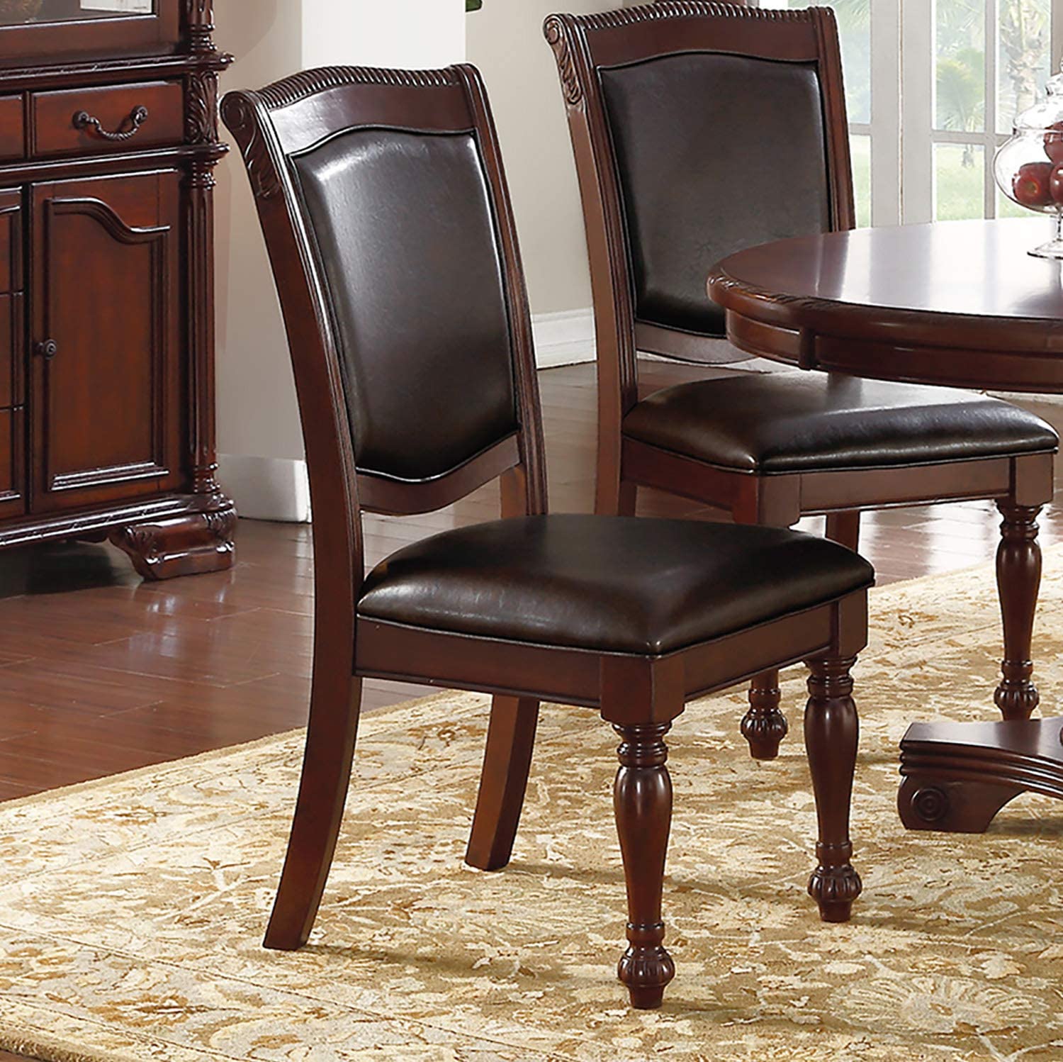Dark brown leather dining chair with carved wood frame and ornate legs on an area rug