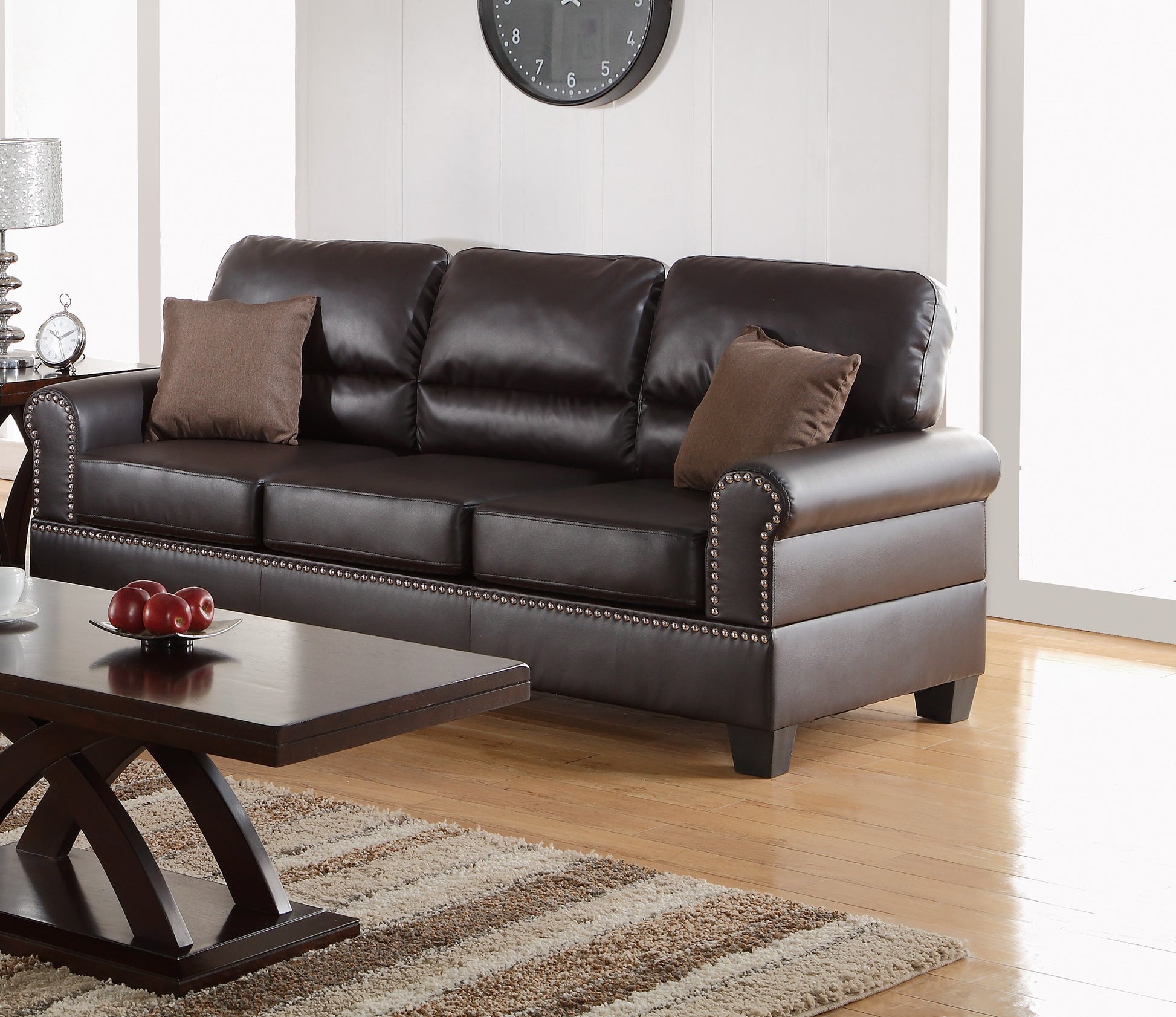 Dark brown leather sofa with nailhead trim and plush cushions