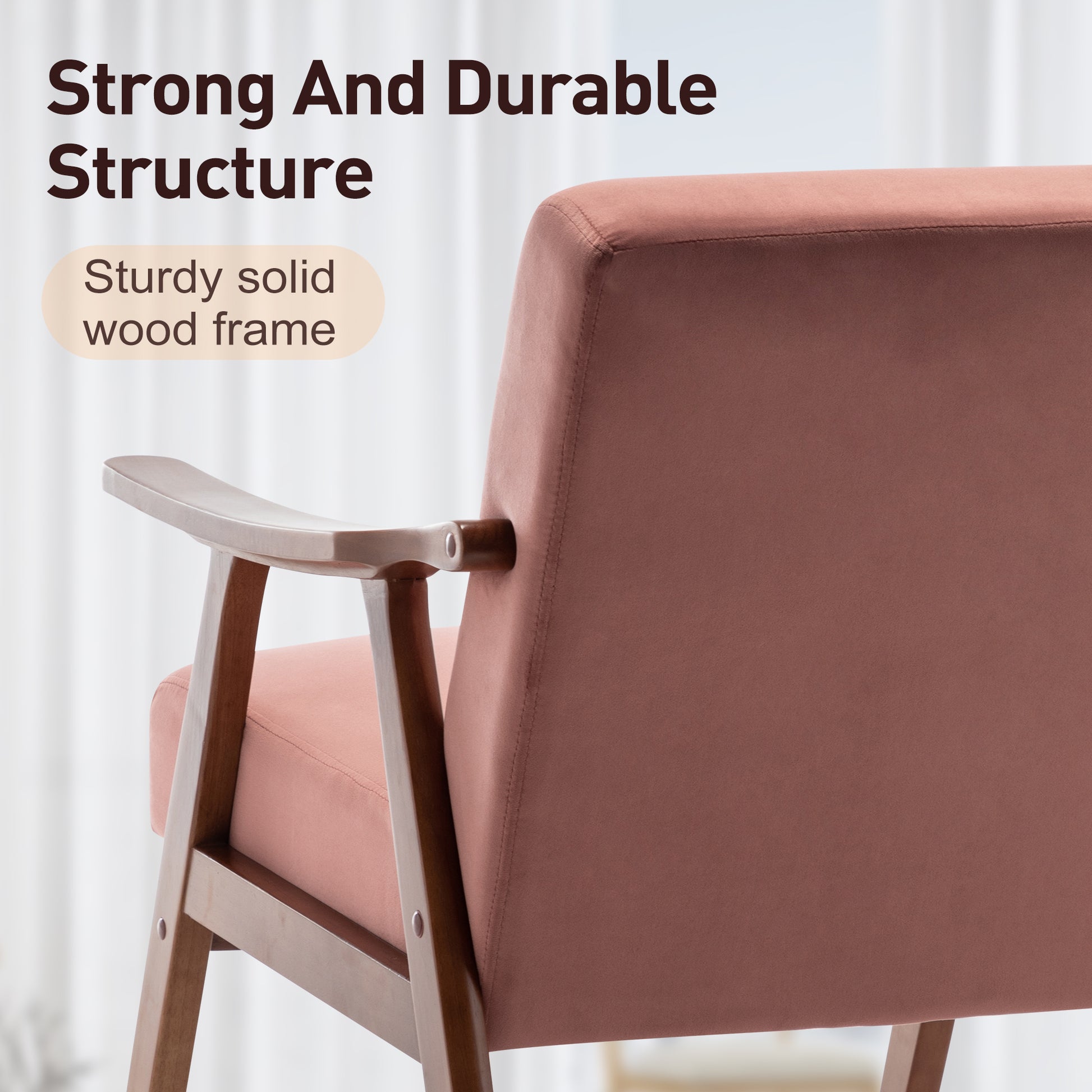Closeup of a dusty rose velvet accent chair with a sturdy solid wood frame