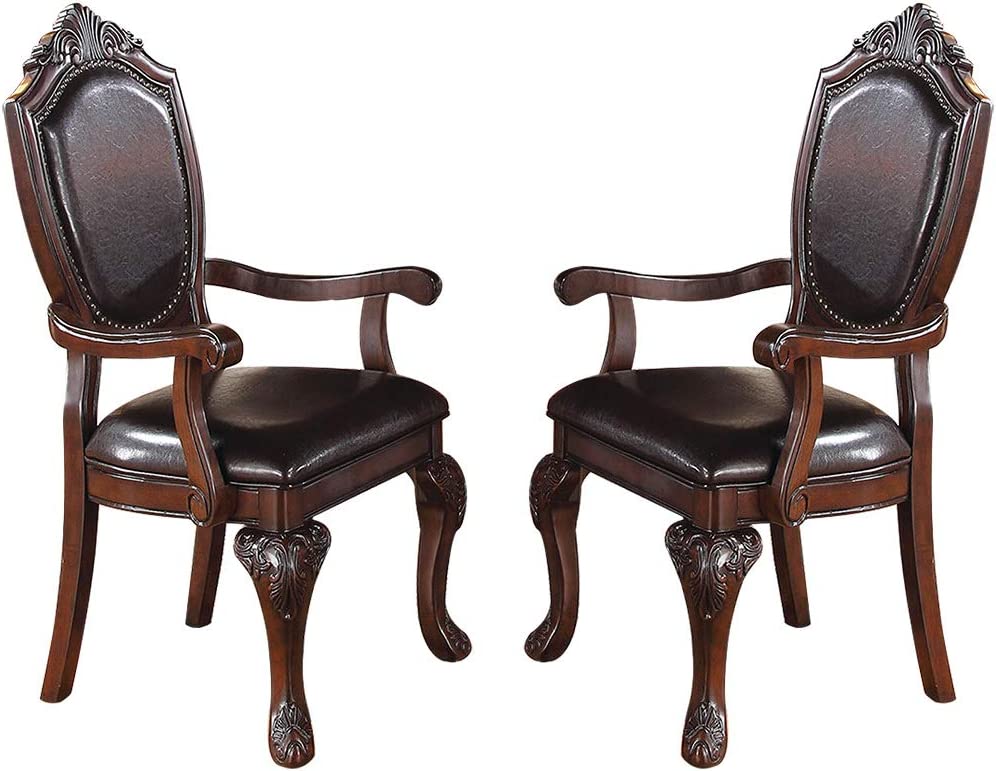 Two dark brown leather upholstered armchairs with ornate carved wooden legs and frames