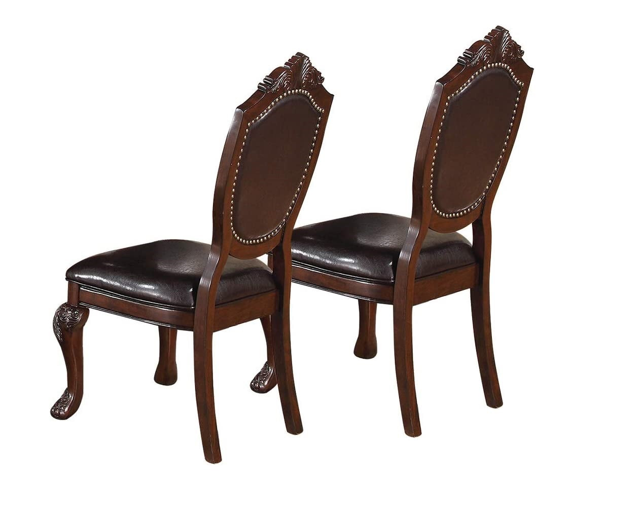 Two ornate dark brown faux leather dining chairs with carved wooden legs and brass nailhead trim