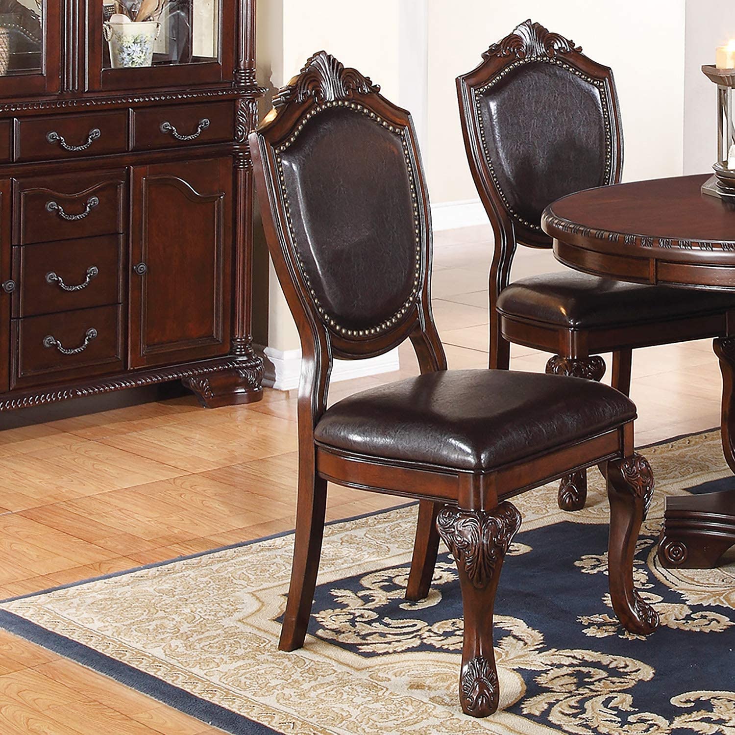 Dark brown leather dining chair with carved wooden legs and ornate backrest