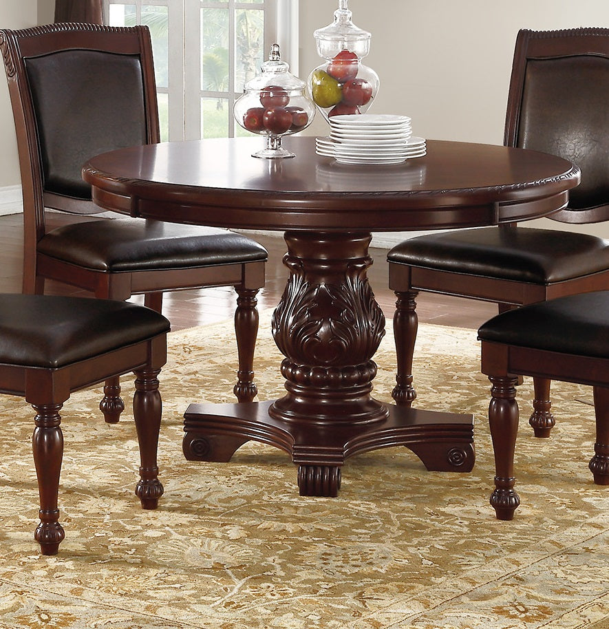 Ornate carved pedestal dining table with four dark brown leather chairs