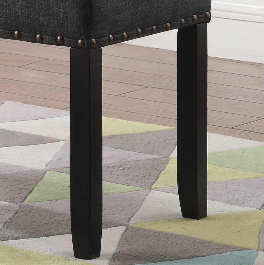 Dark gray upholstered bench detail with brass nailhead trim