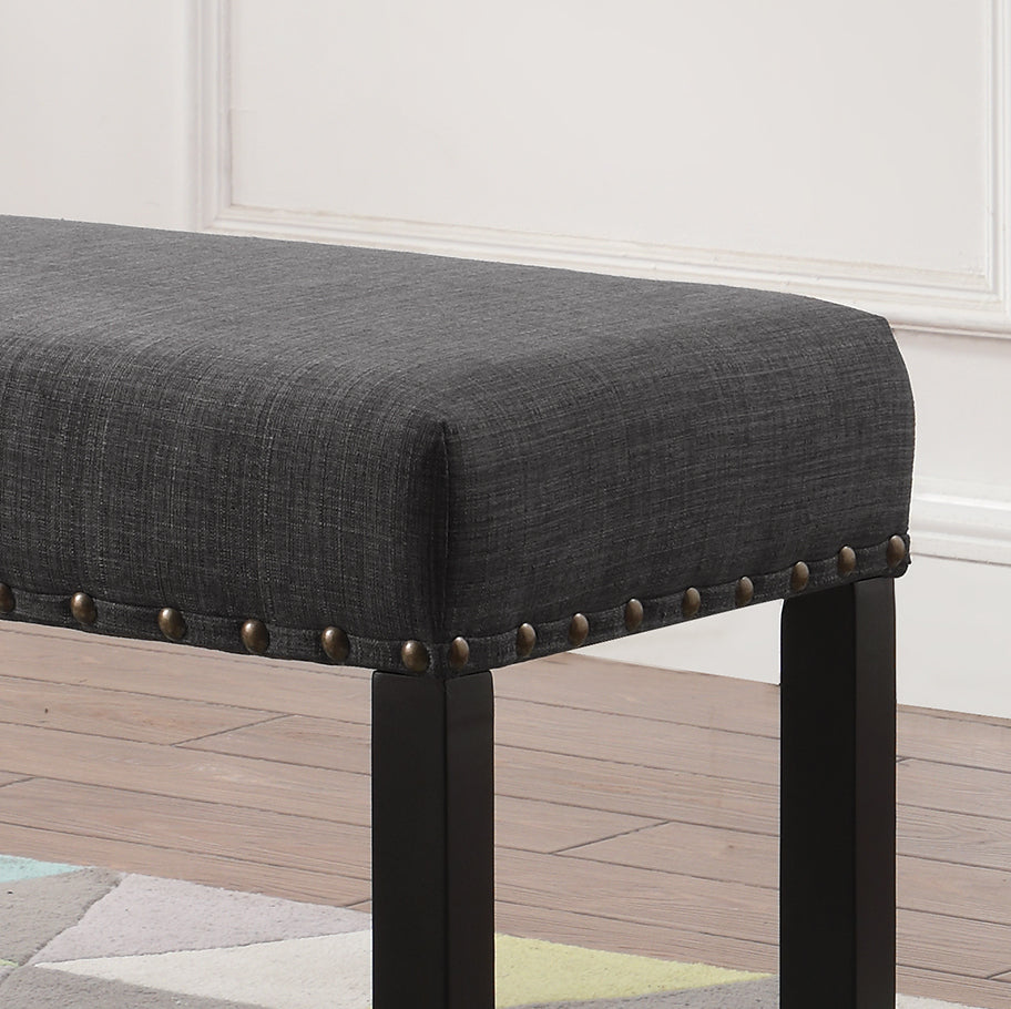 Tufted charcoal grey fabric ottoman bench with decorative brass nailhead trim