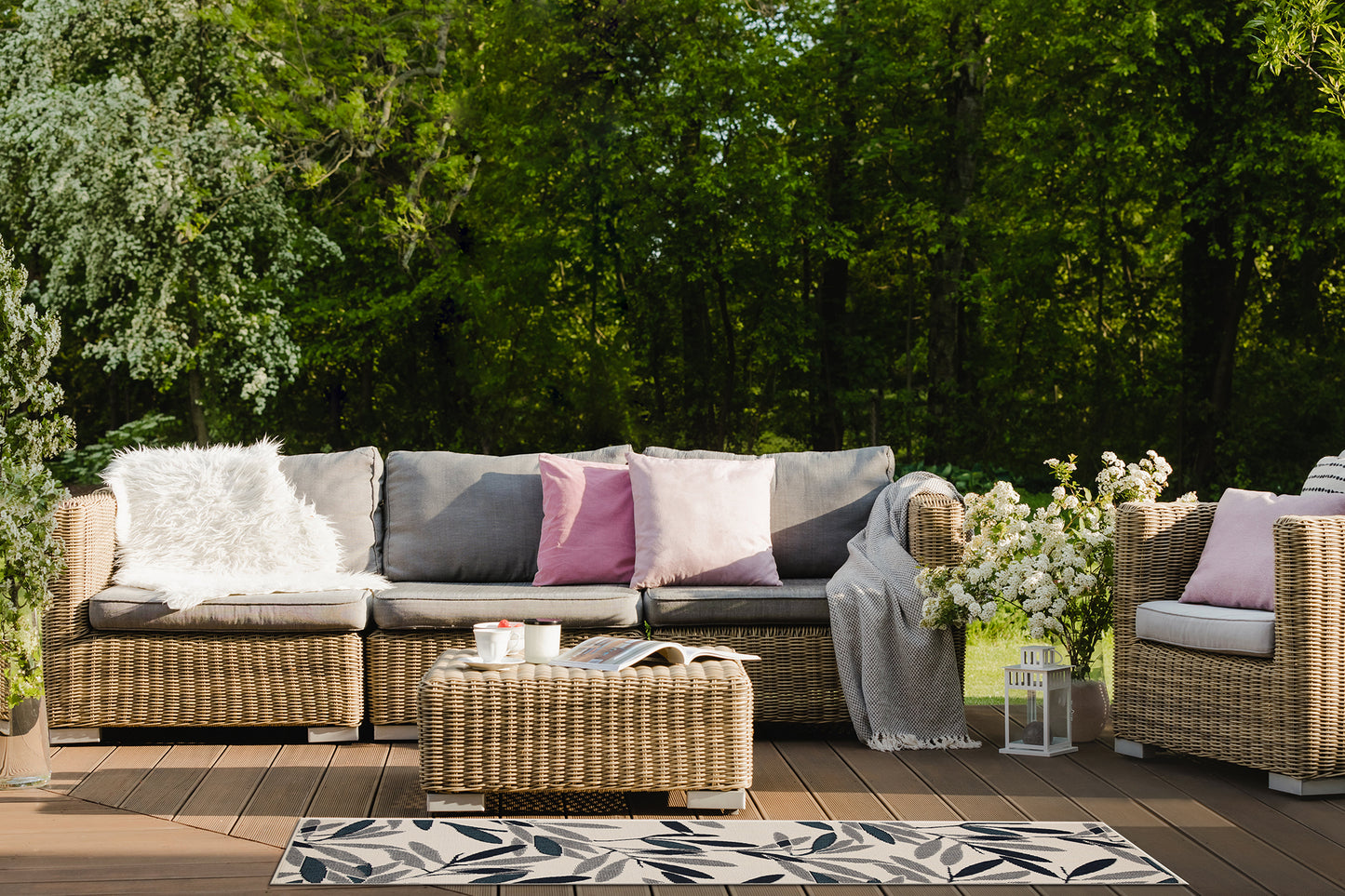 Wicker outdoor sofa with plush grey cushions and white faux fur throw pillow