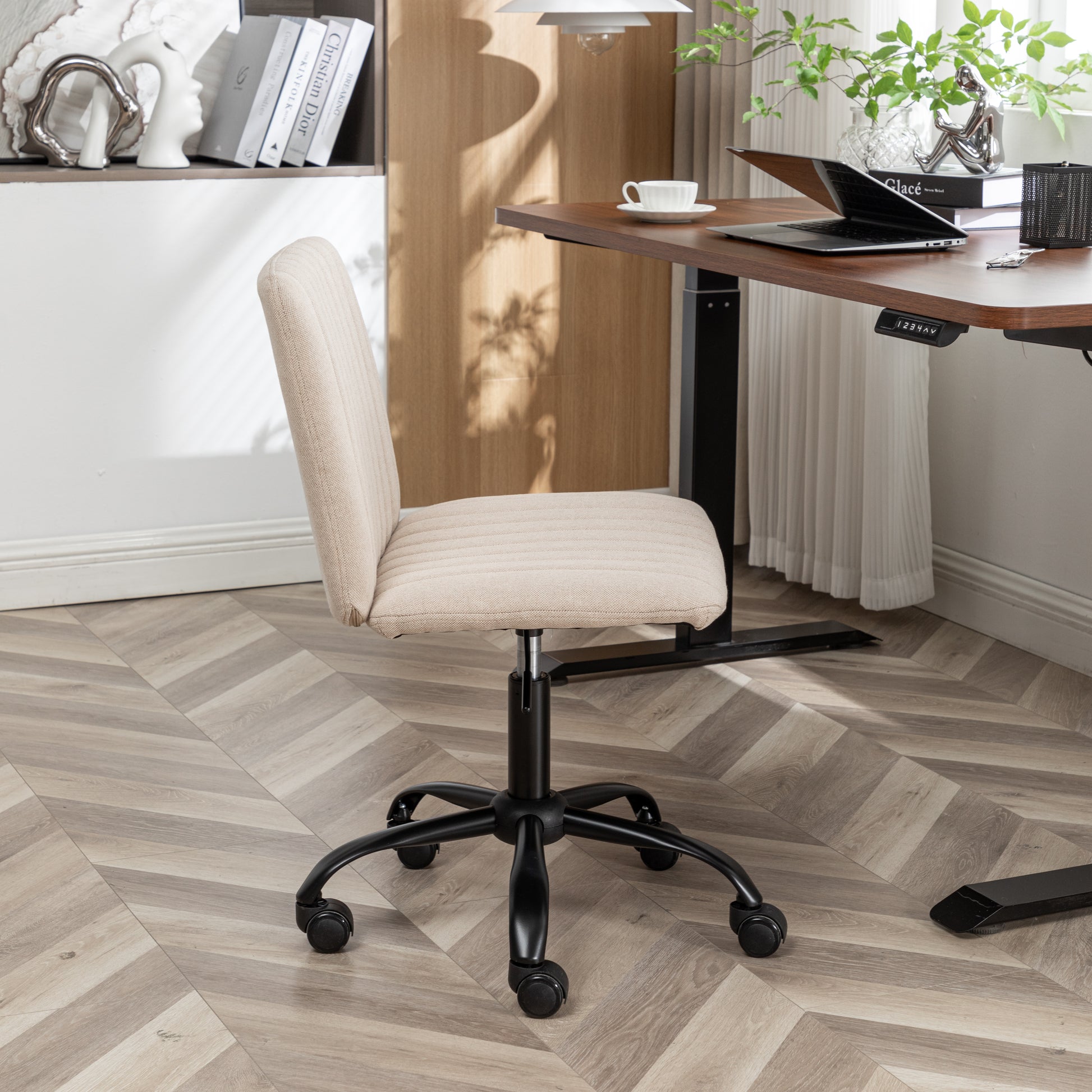 Beige upholstered desk chair with adjustable height and black casters