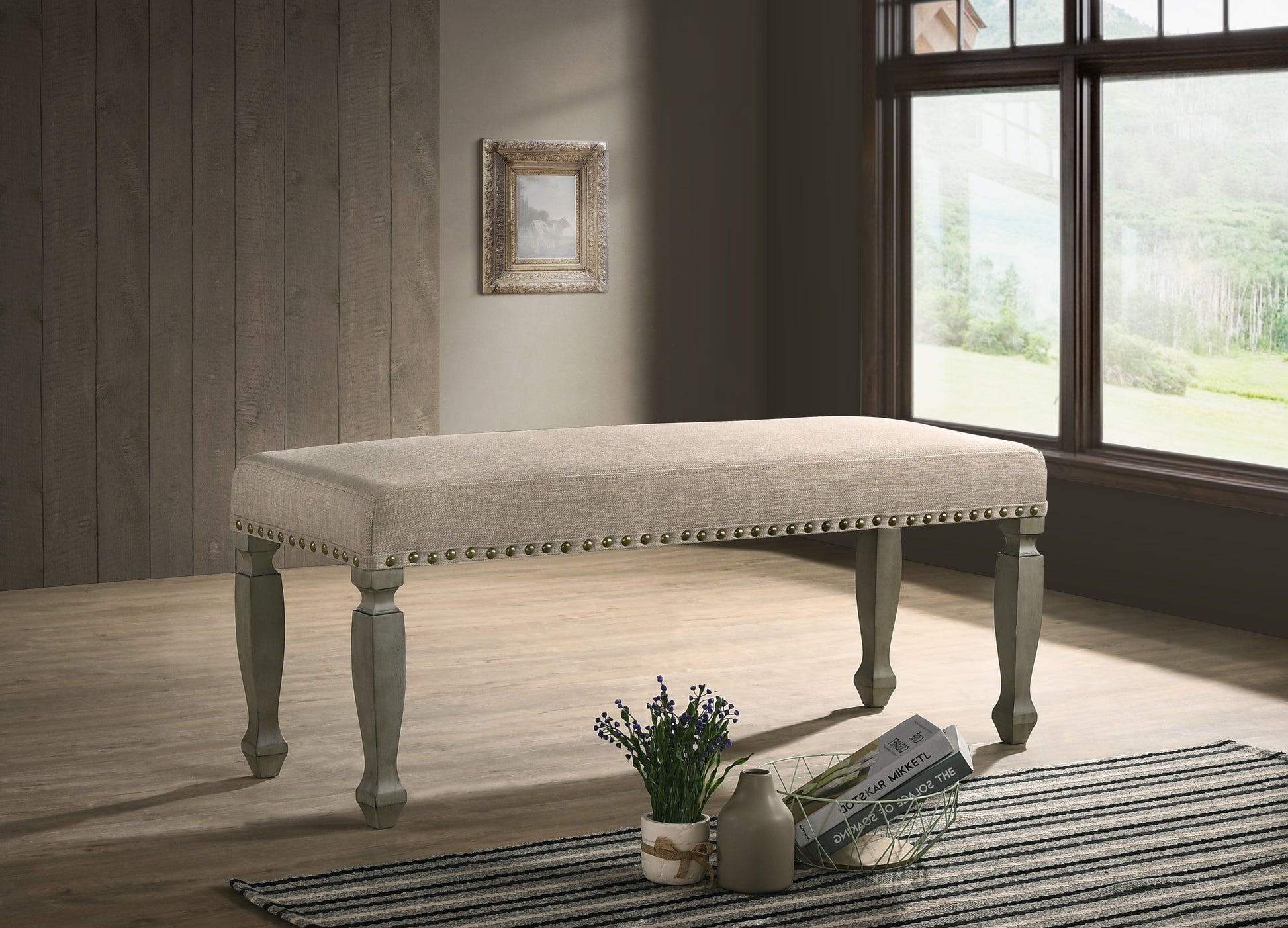 Beige upholstered dining bench with nailhead trim and carved wooden legs