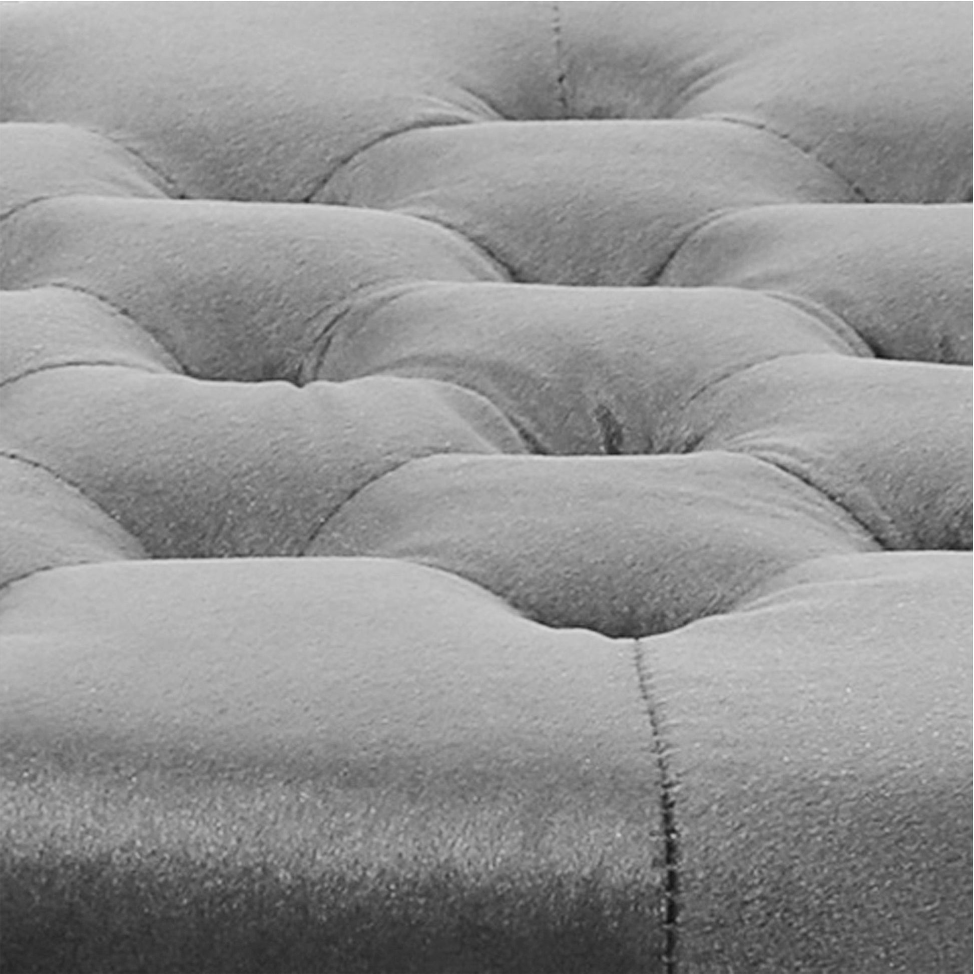 Closeup of grey tufted velvet upholstery fabric on a sofa cushion offering a luxurious texture