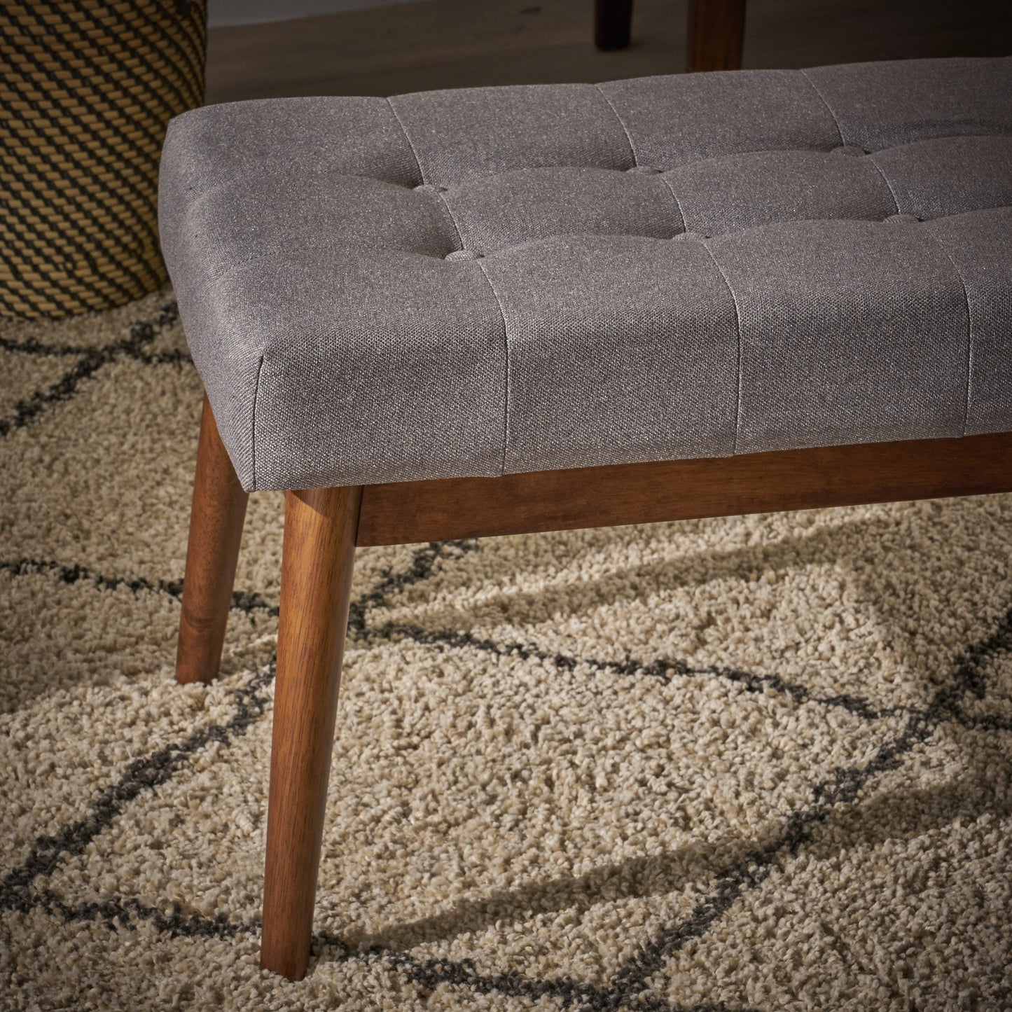 Tufted grey fabric bench with angled wood legs ideal for entryway seating