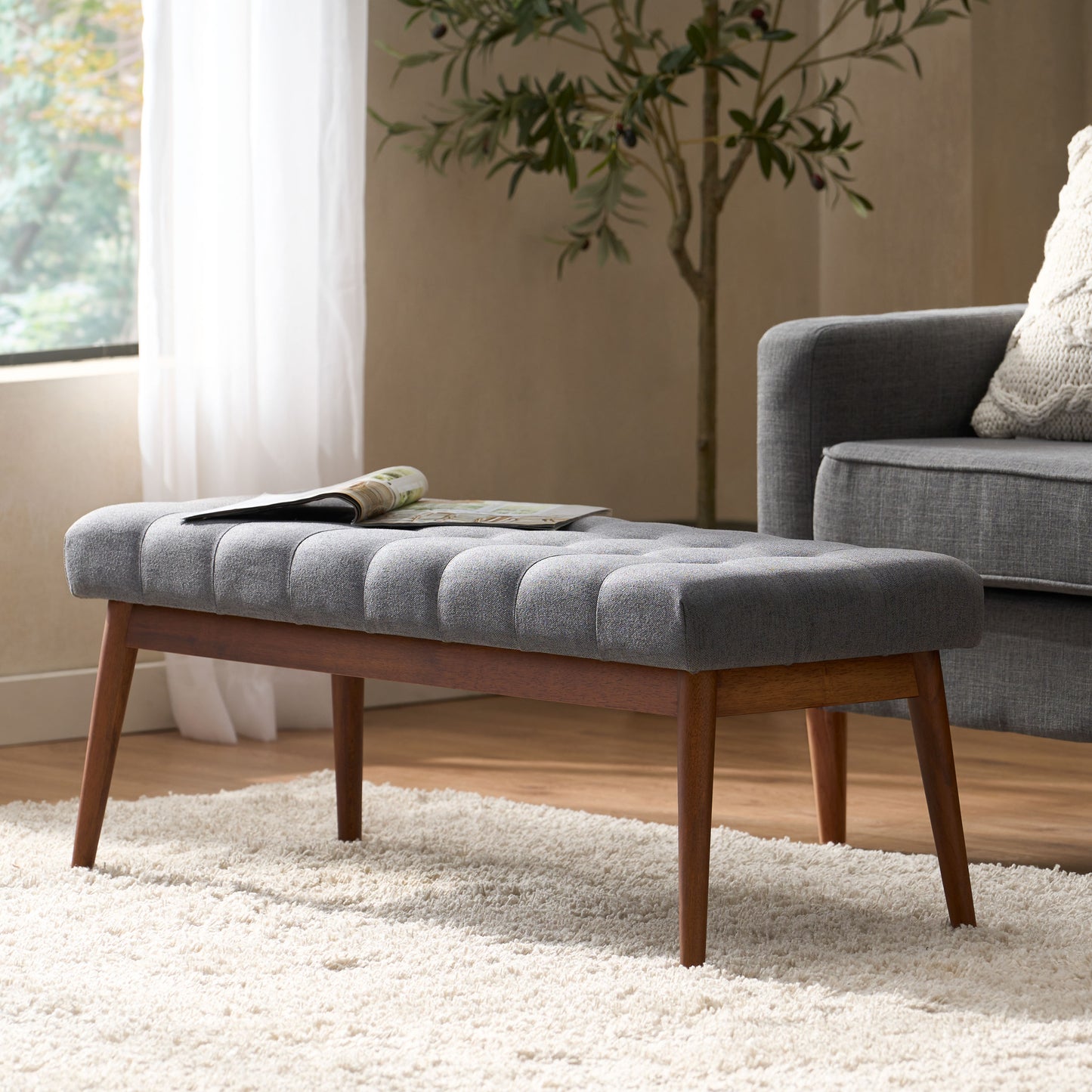 Tufted grey fabric bench with midcentury modern wooden legs