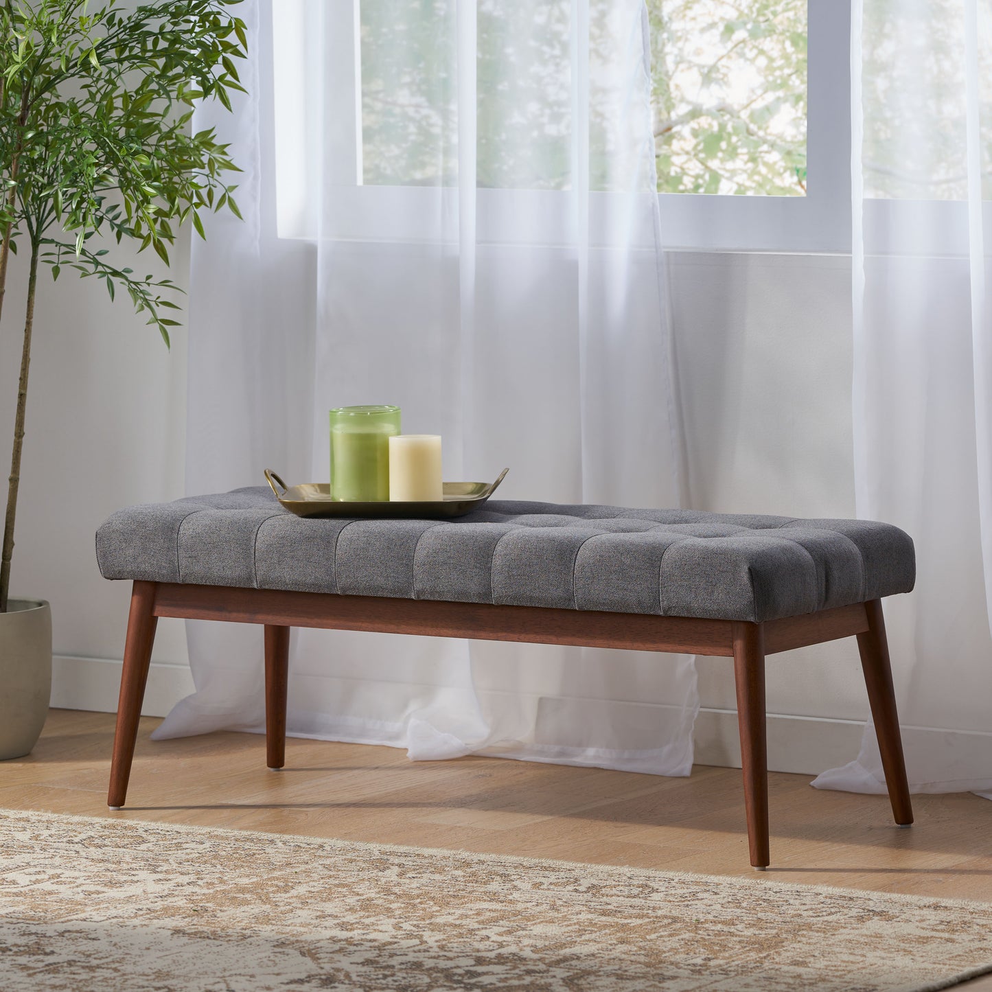 Tufted grey fabric bench with tapered wooden legs ideal for entryways