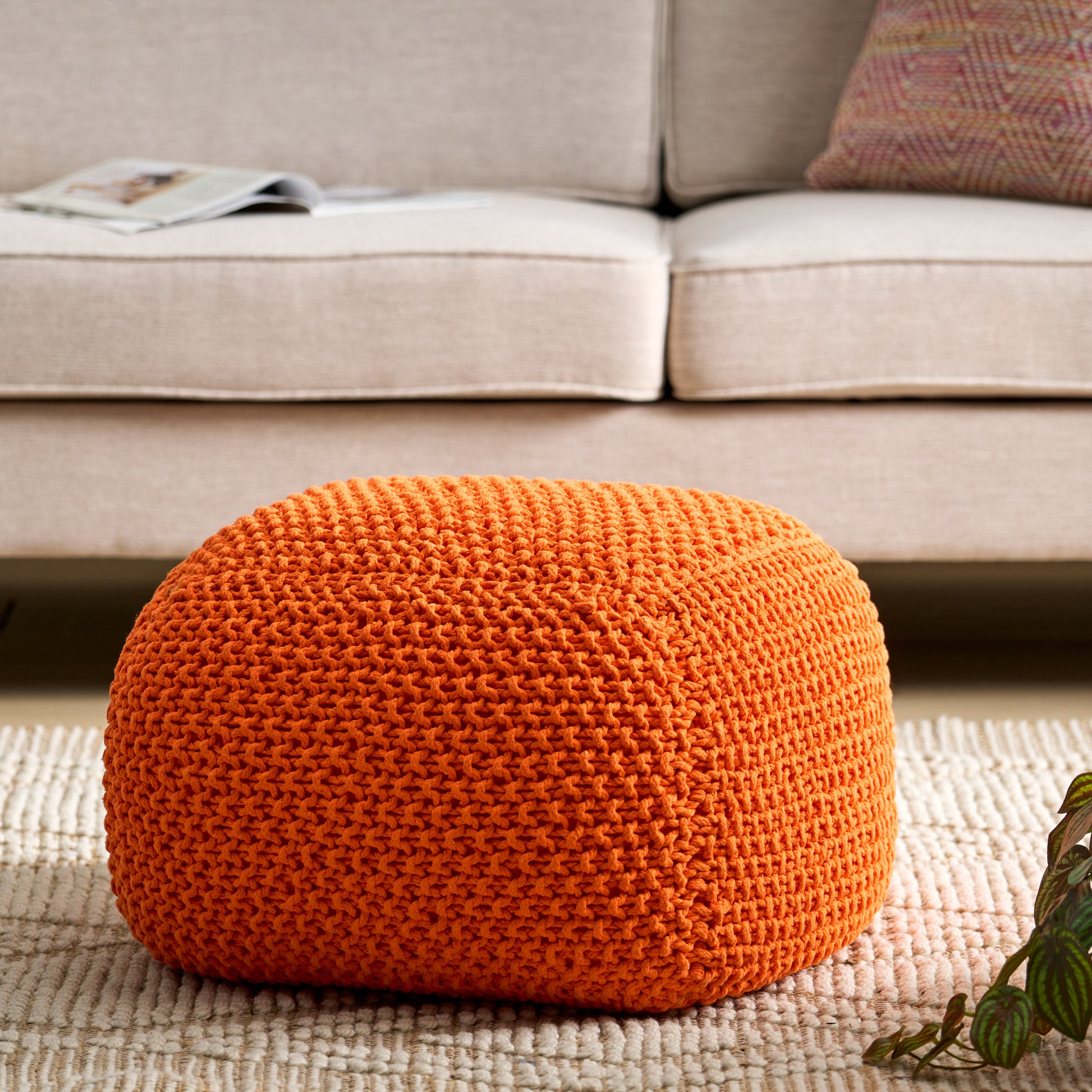 Orange knit pouf with textured stitch detail perfect for footrest