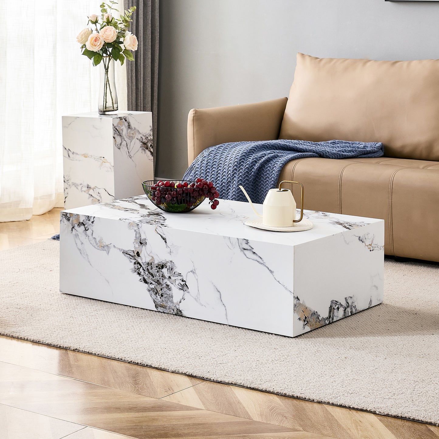 Rectangular white marble coffee table with grey and gold veining featuring a bowl of grapes
