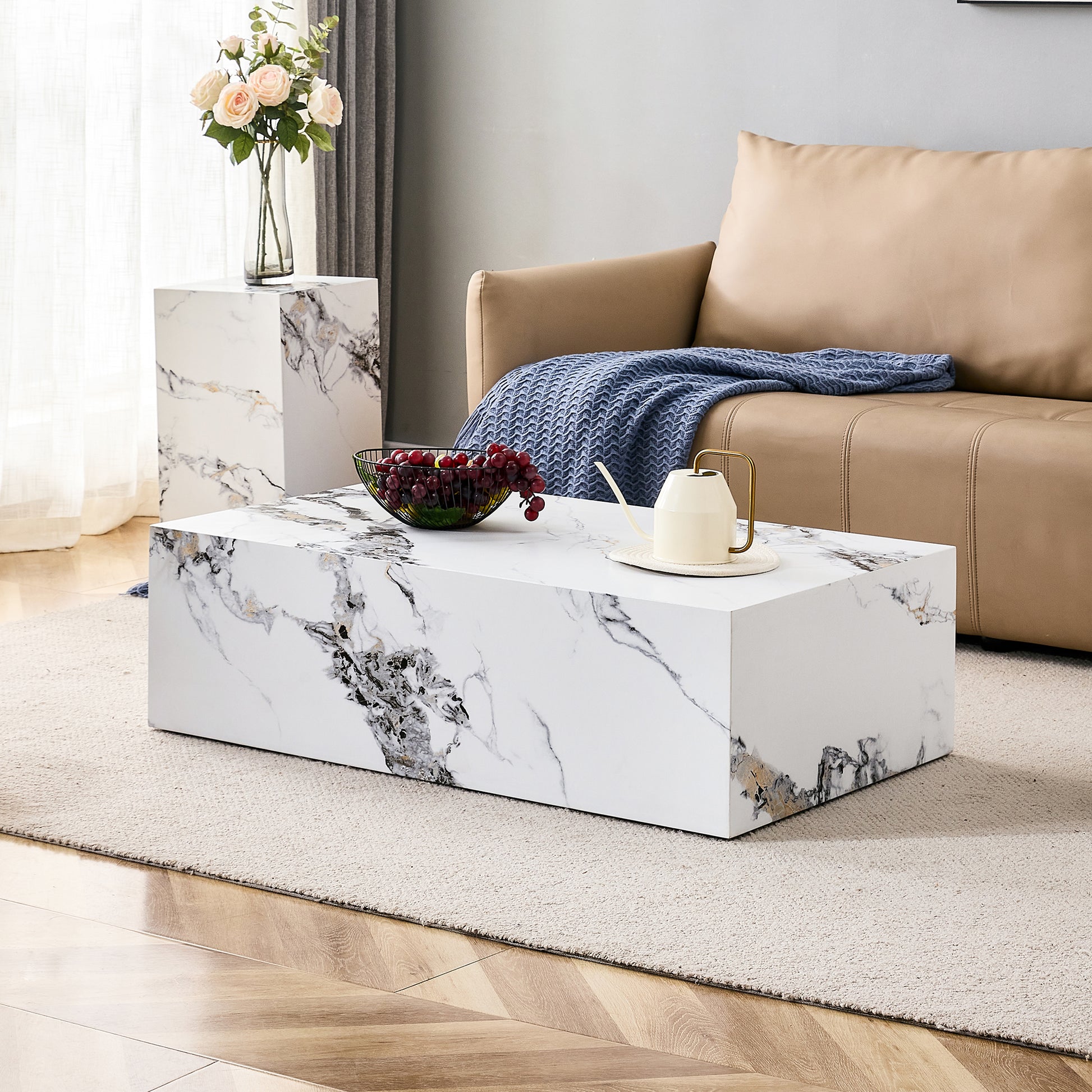 Rectangular white marble coffee table with grey and gold veining featuring a bowl of grapes
