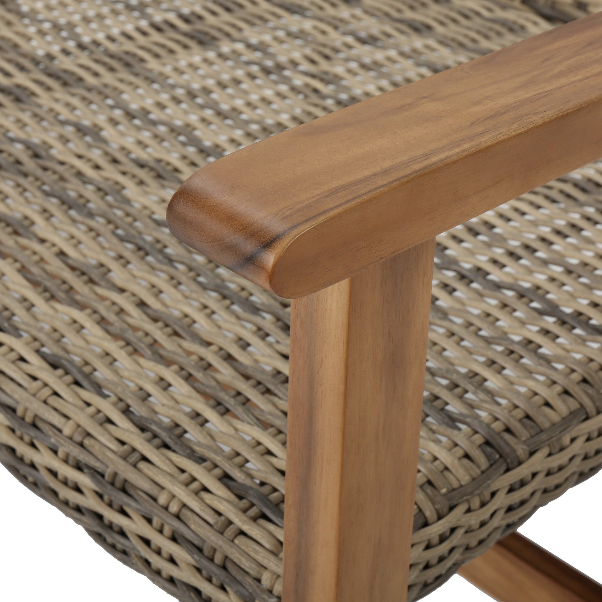 Closeup of acacia wood armrest on woven outdoor chair with grey and tan wicker