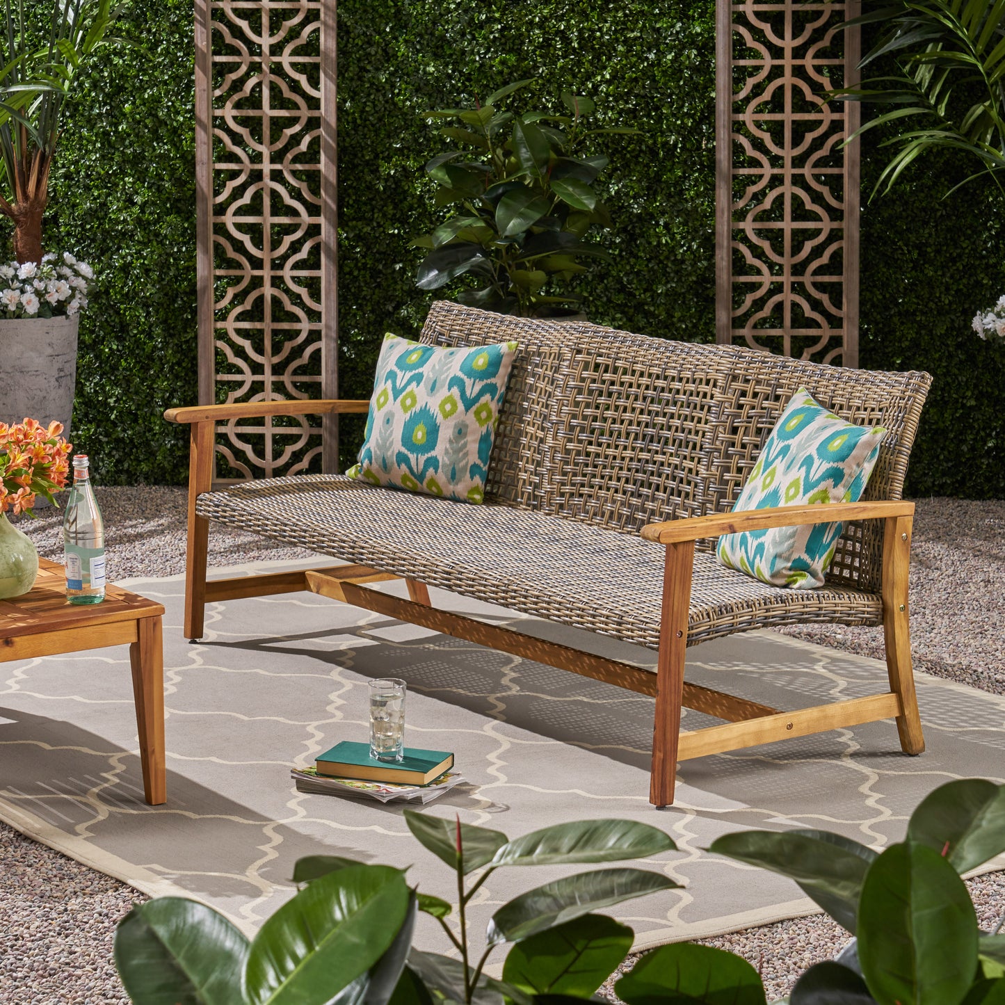 Wicker outdoor loveseat with wooden frame and patterned cushions