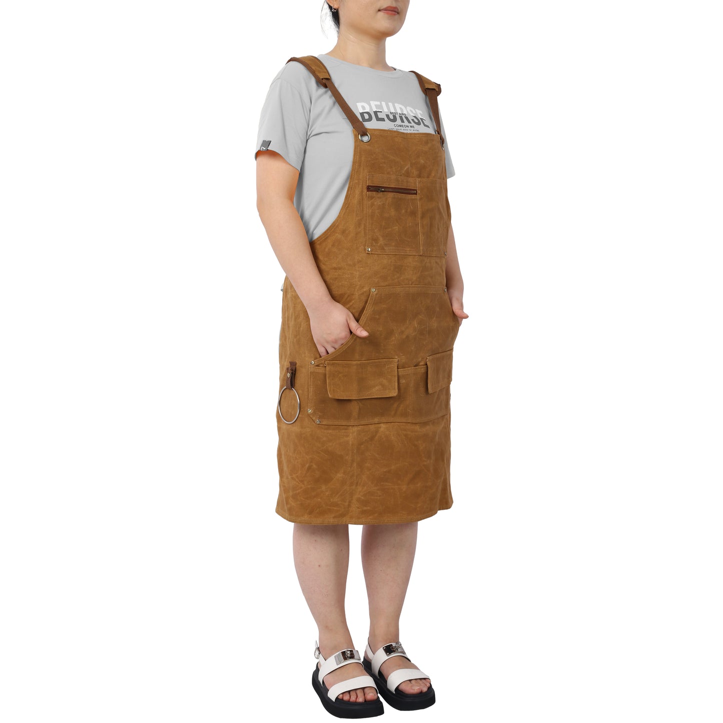 Brown waxed canvas apron with multiple pockets and crossback straps for utility