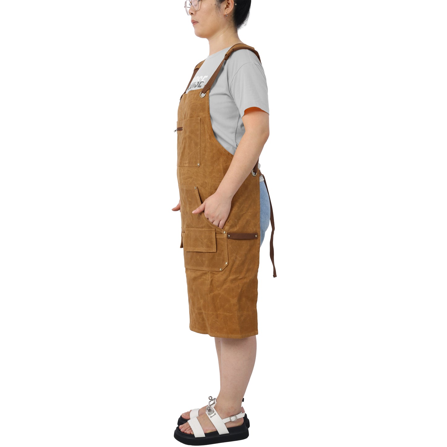 Brown canvas bib apron with multiple pockets and leather accents ideal for workwear