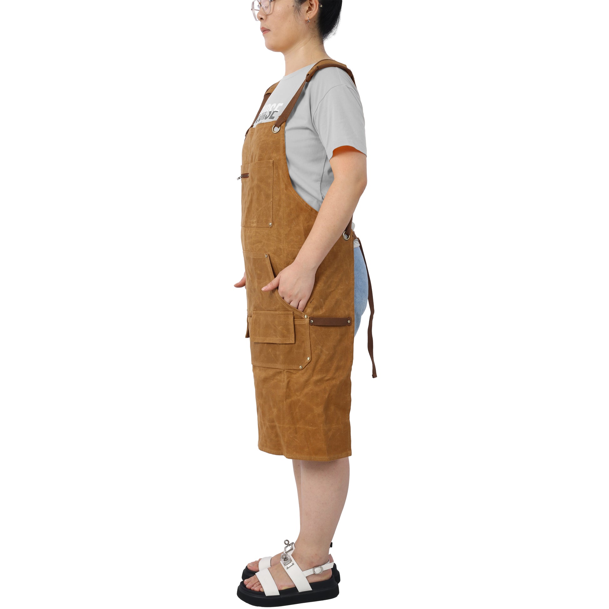 Brown canvas bib apron with multiple pockets and leather accents ideal for workwear