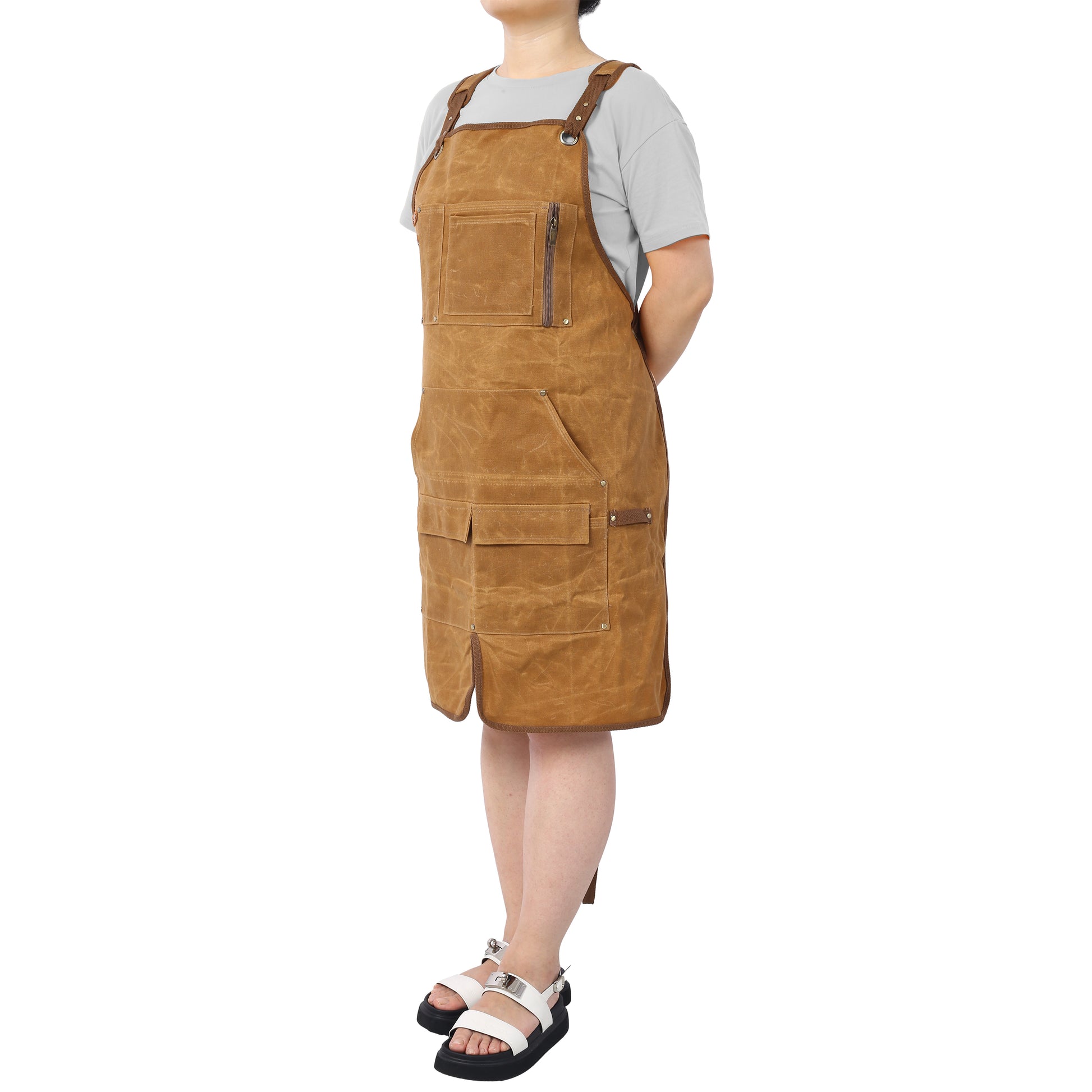 Brown canvas bib apron with multiple pockets and leather accents for artisans