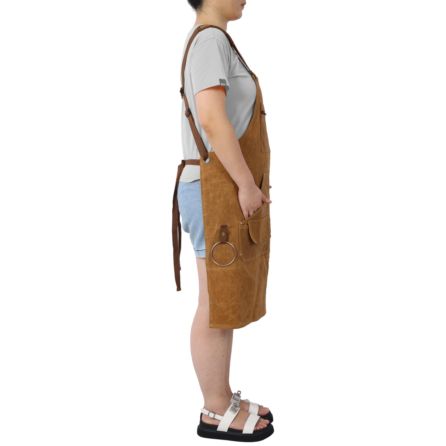 Durable brown canvas apron with multiple pockets and adjustable straps for comfortable workwear
