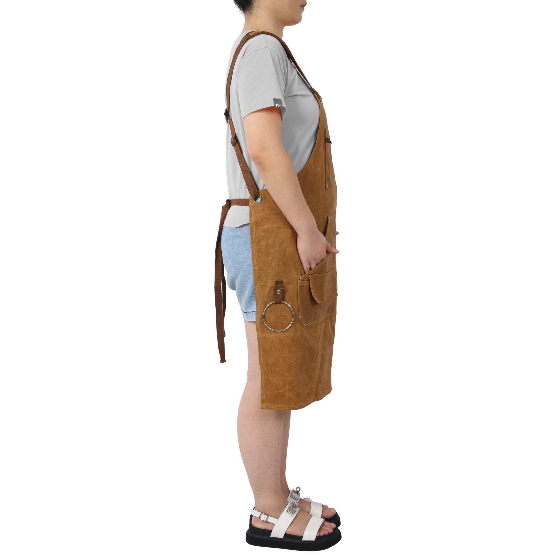 Durable brown canvas apron with multiple pockets and adjustable straps for comfortable workwear