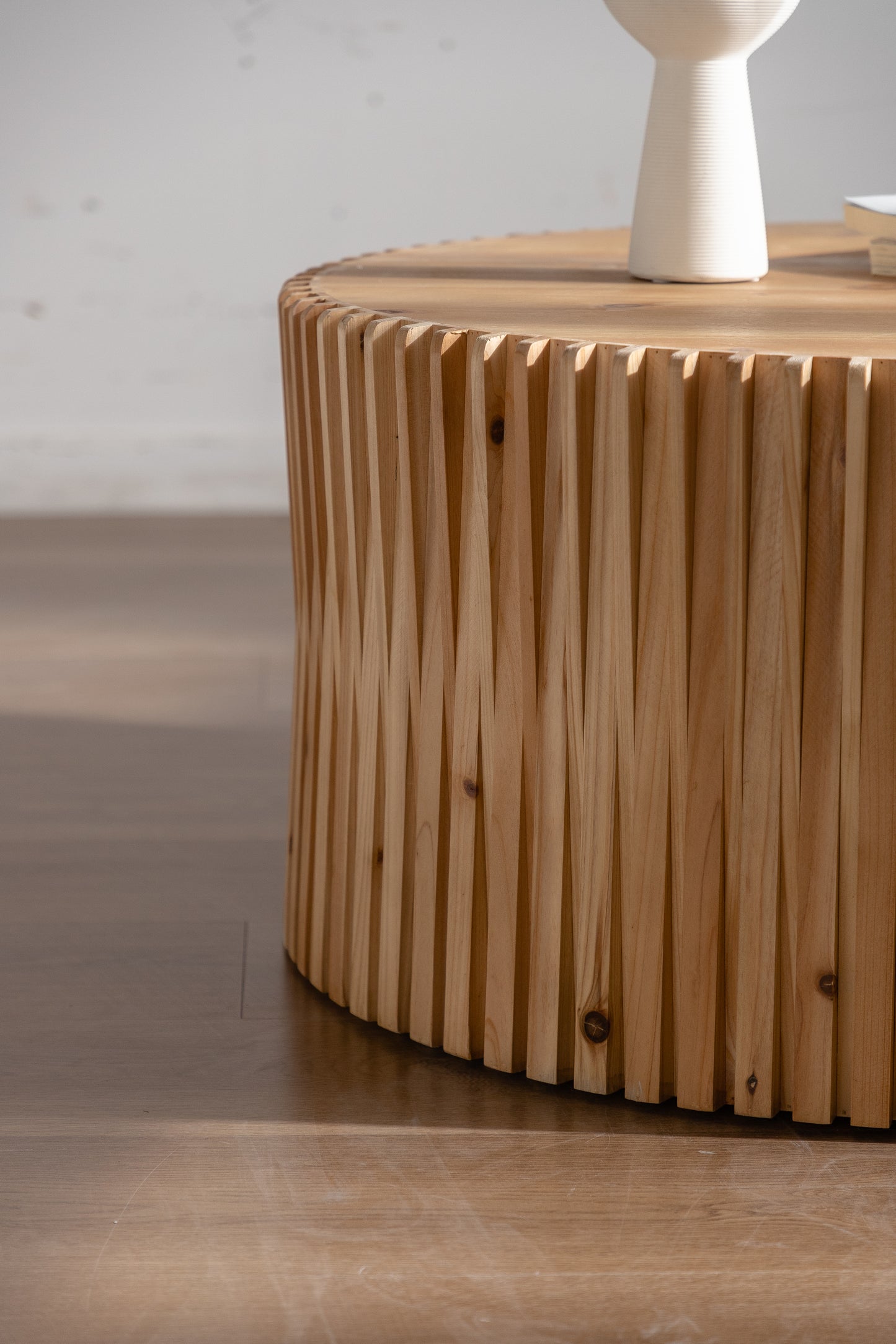 Round wooden coffee table with fluted design and natural wood finish