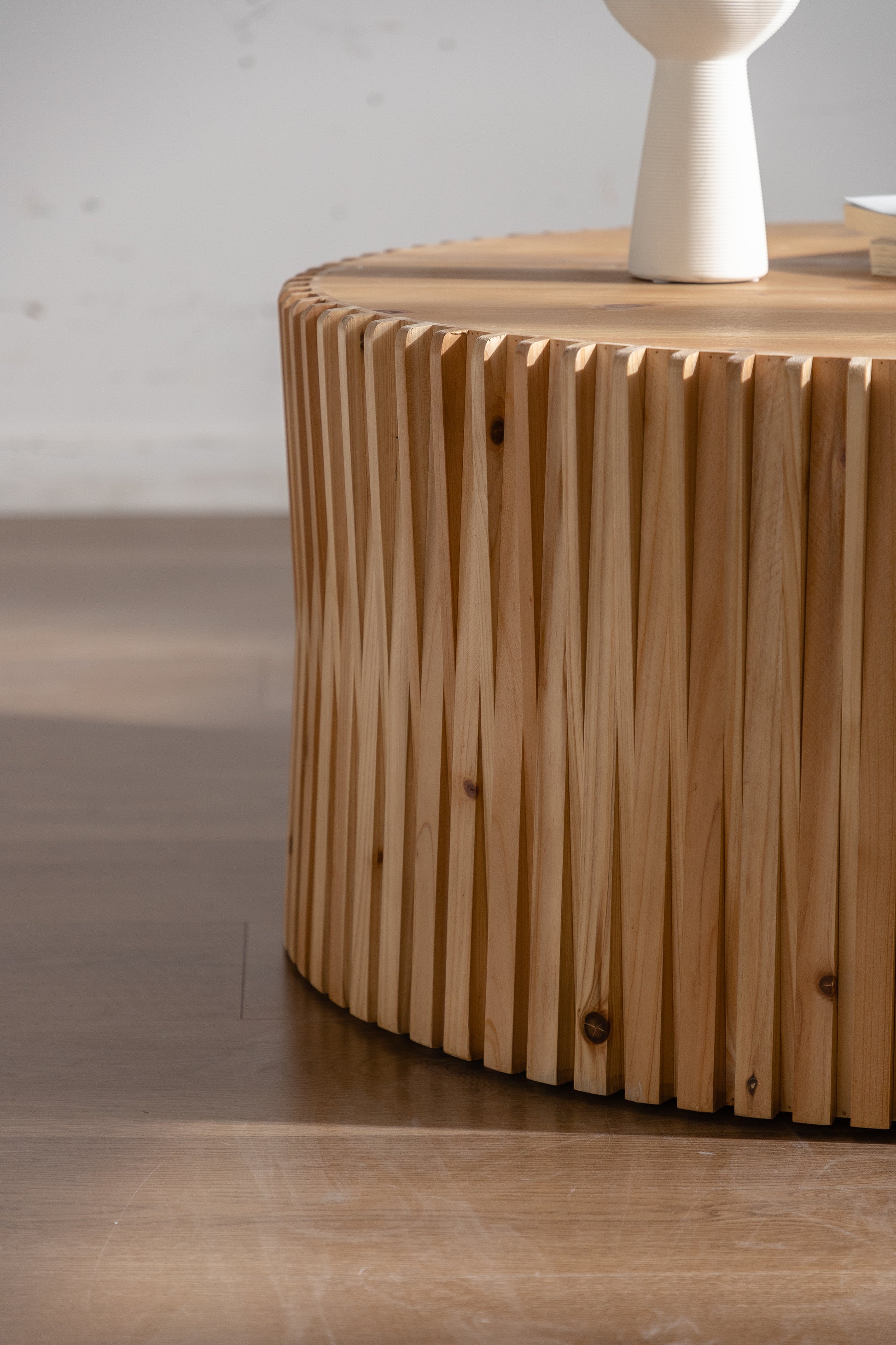 Round wooden coffee table with fluted design and natural wood finish